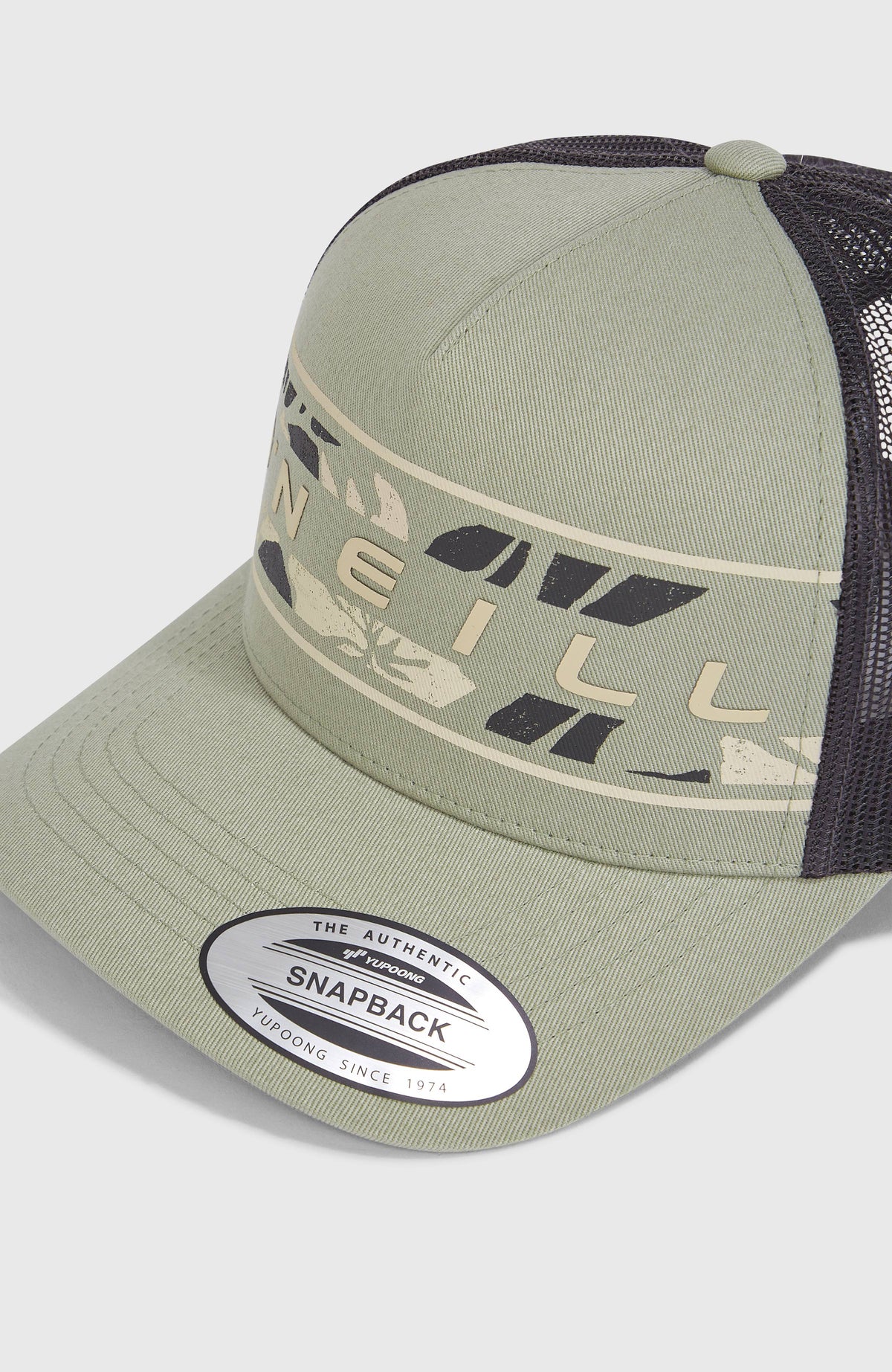 Nahaufnahme von Schirm und Frontpanel der grünen Flower Trucker Cap mit Blumenmuster in Beige und Schwarz