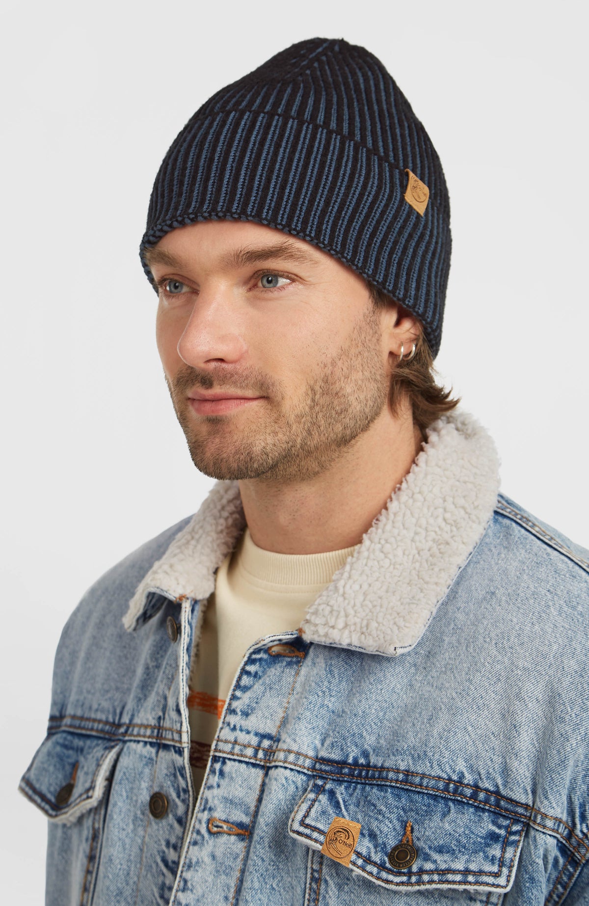 O'Riginals Beanie, blau, Halbprofilansicht getragen am Model mit Logo-Aufnäher am Umschlag
