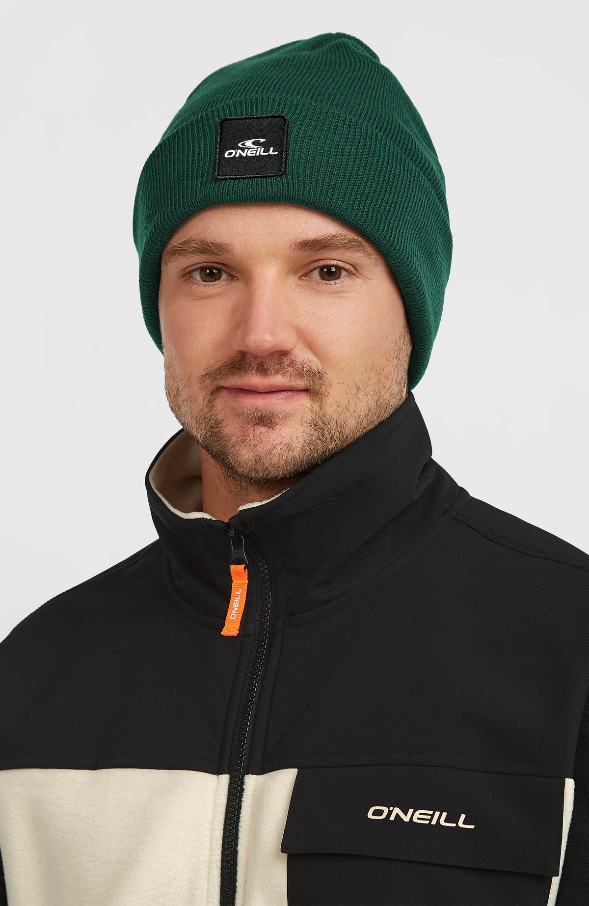 Snow Beanie für Herren, grün, getragen am Model, Frontalansicht mit Logo-Aufnäher
