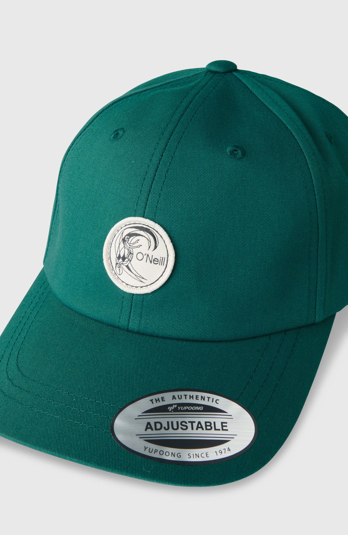 Nahaufnahme der grünen O'Riginals Badge Cap, freigestellt mit rundem Logo-Patch und Schirm