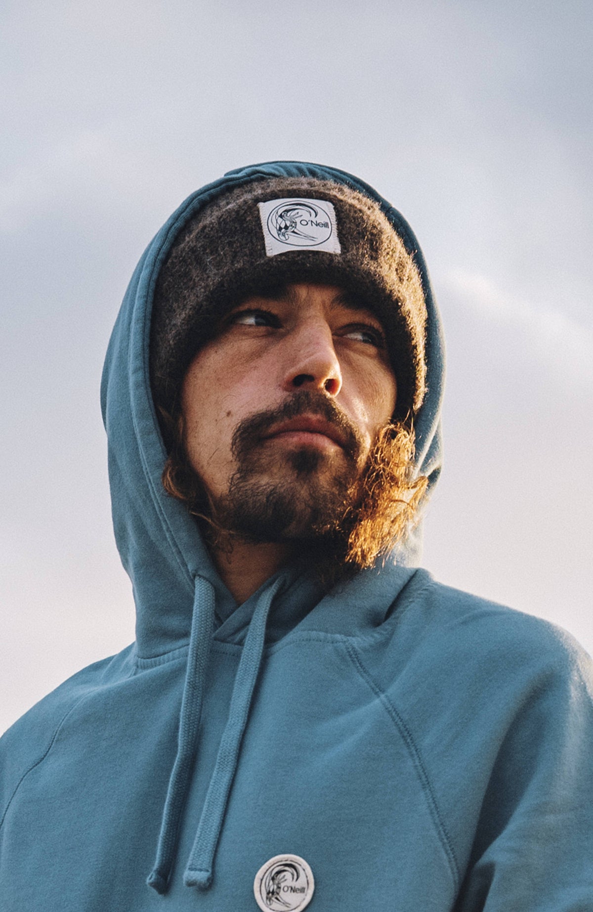 O'Riginals Beanie für Herren, lila, getragen am Model unter einer Kapuze im Freien