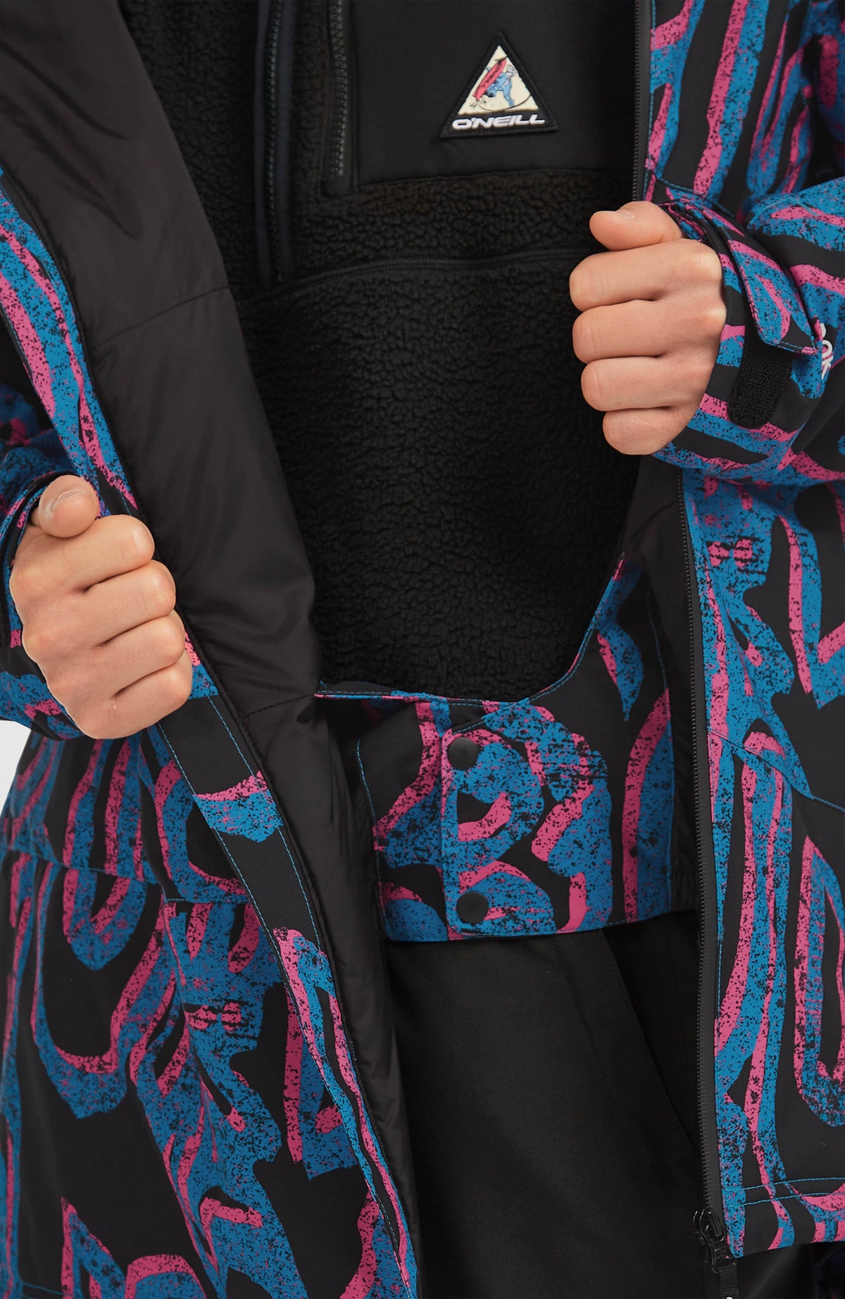 Nahaufnahme des integrierten Schneefangs der pinken FWC'Play Asymmetric Ski- und Snowboardjacke