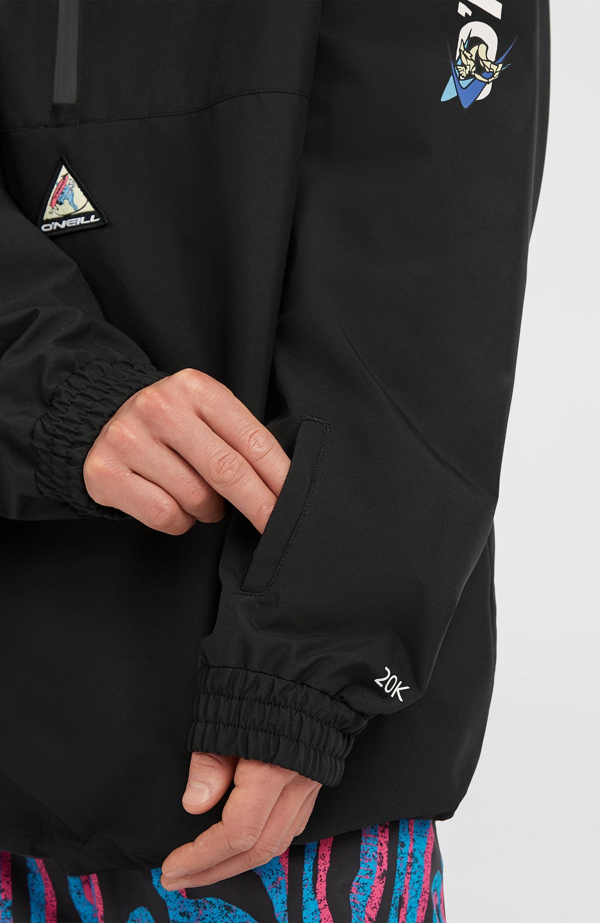 Nahaufnahme von Ärmeltasche und Bündchen der schwarzen FWC'Play Park Ski- und Snowboardjacke am Model