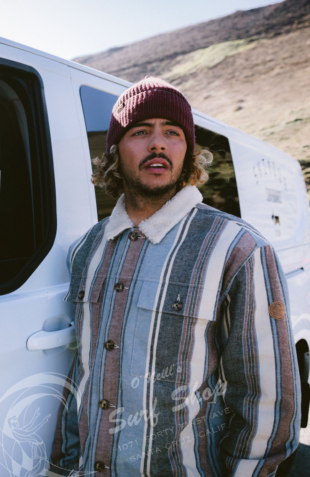 O'Riginals Jacke mit Fleecefutter für Herren, blau mit Streifenmuster in Braun, am Model neben einem Van