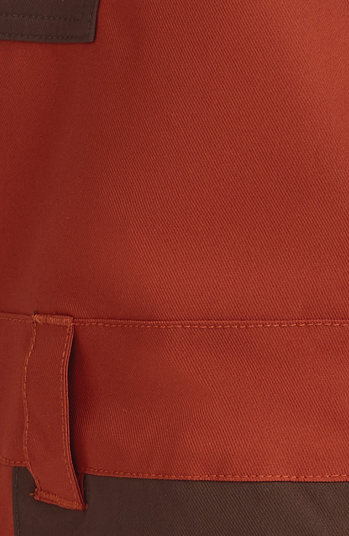 Nahaufnahme von Bund und Gürtelschlaufe der orangen FWC'Peak Bib Skihose