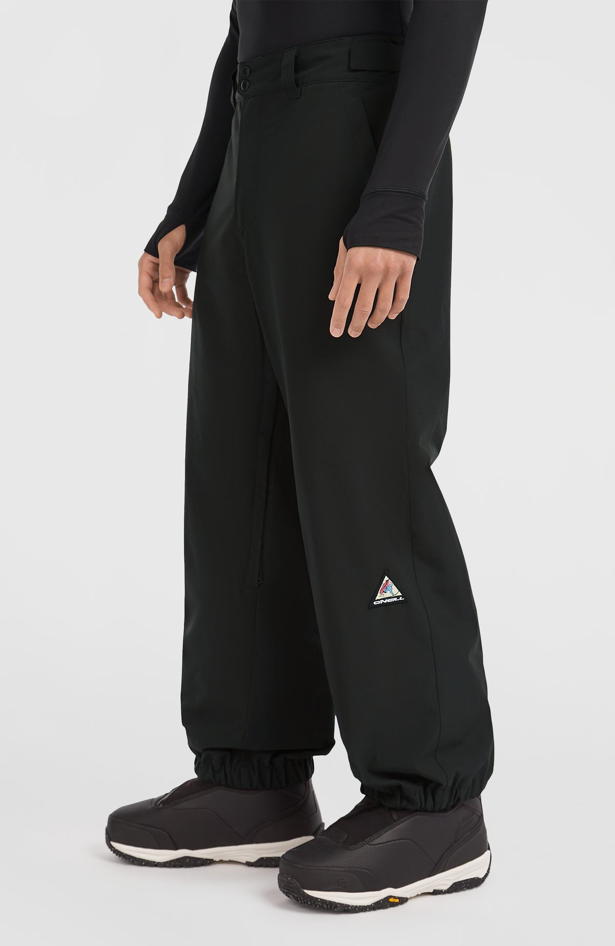 FWC'Play Ski- und Snowboardhose für Herren, schwarz, Seitenansicht am Model mit Logo-Patch am Hosenbein