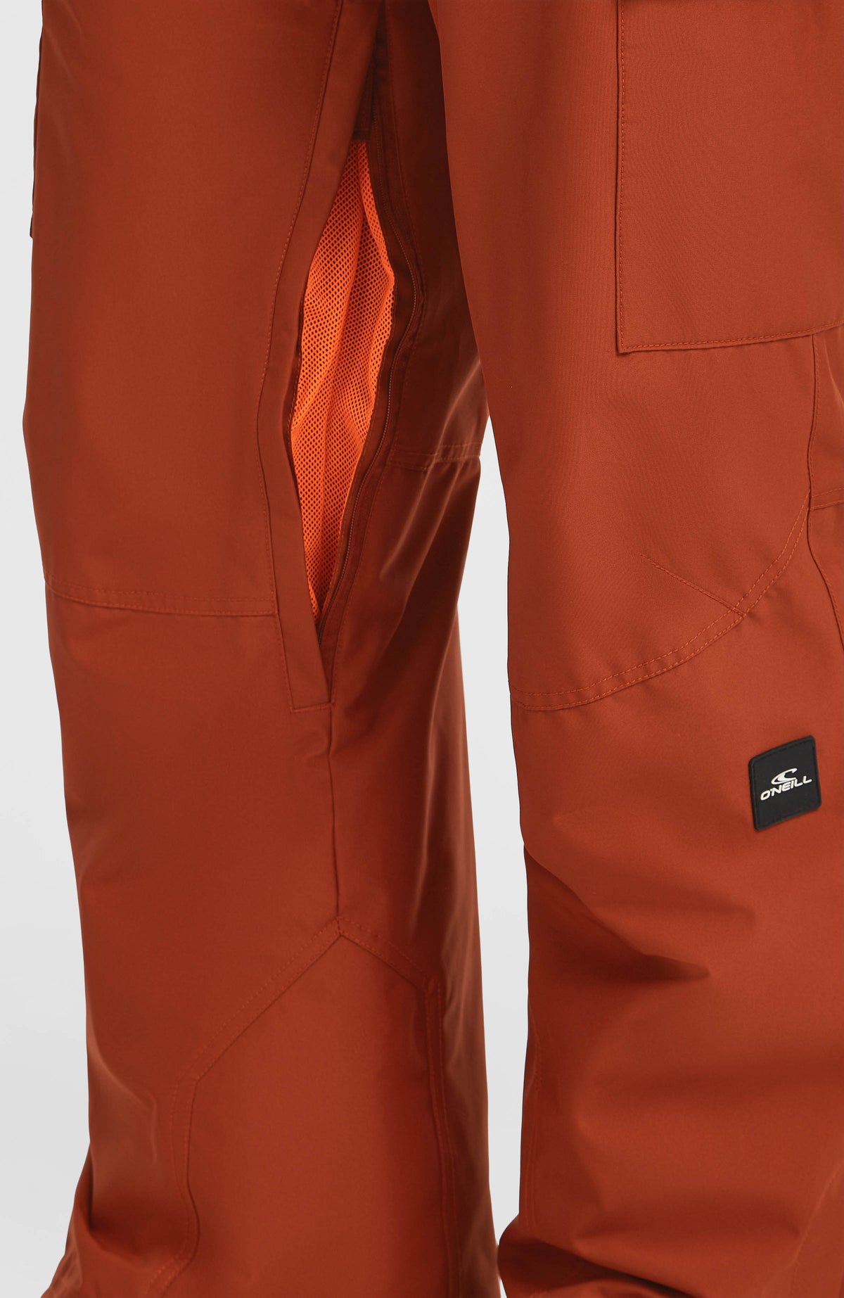 Nahaufnahme des geöffneten Belüftungsreißverschlusses mit Mesh-Einsatz der orangen FWC'Cruz Cargo-Skihose