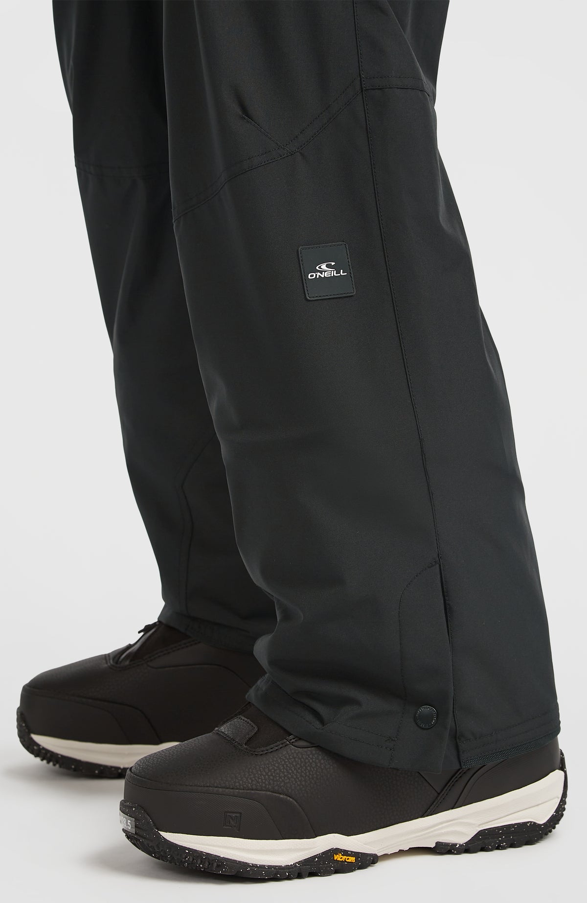 FWC'Cruz Cargo-Skihose, schwarz, Nahaufnahme des Hosenbeins mit Logo-Aufnäher und Druckknopf