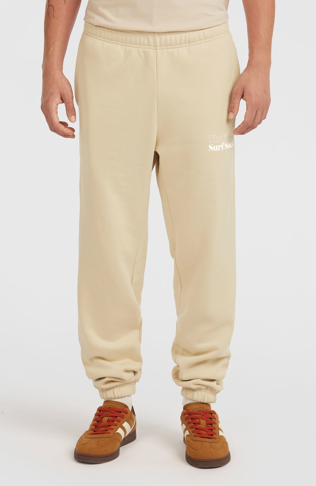 Future Surf Society Jogginghose für Herren, beige mit Logo-Print in Weiß, Vorderansicht am Model mit elastischem Bund