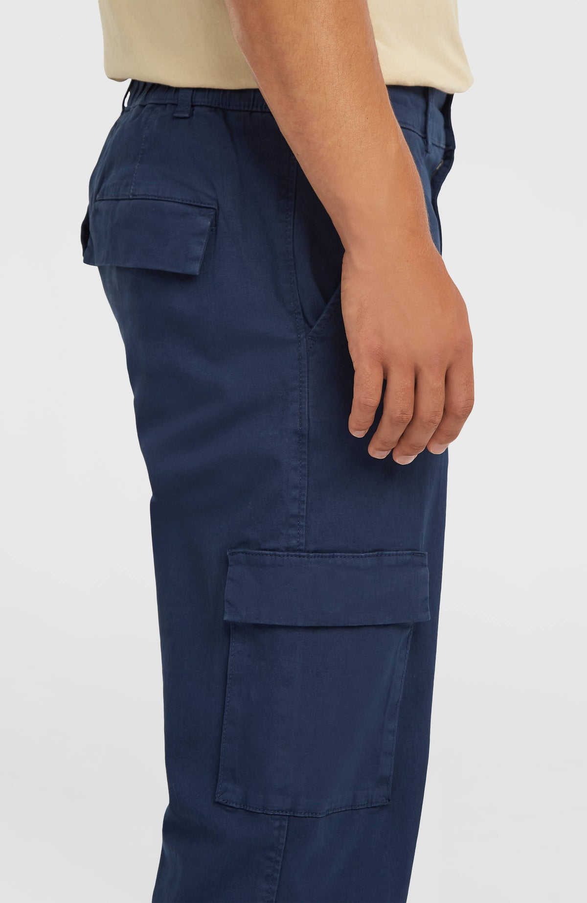 Nahaufnahme der blauen Essentials Cargohose am Model von der Seite mit aufgesetzter Tasche