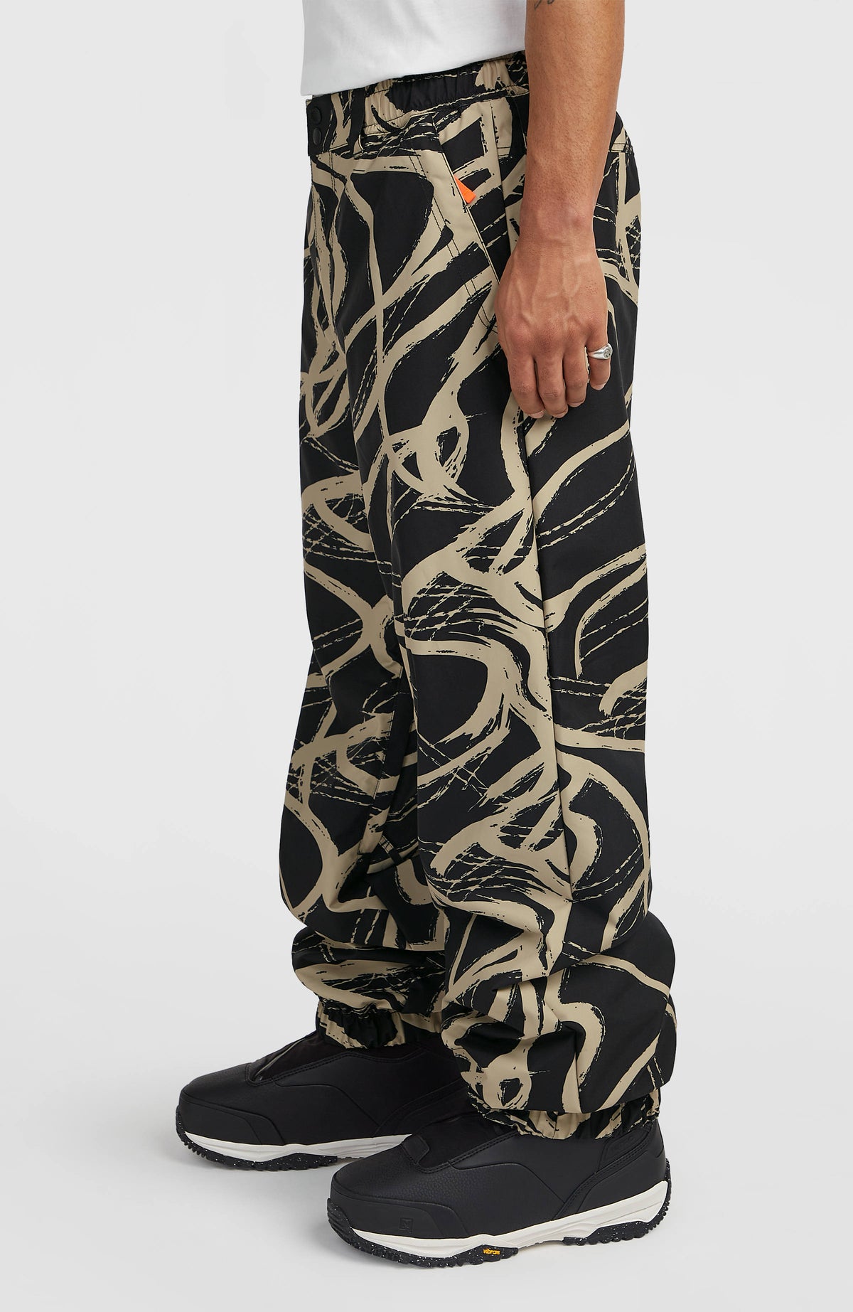 FWC Oversized Ski- und Snowboardhose für Herren, beige mit Grafikmuster in Schwarz, Seitenansicht am Model