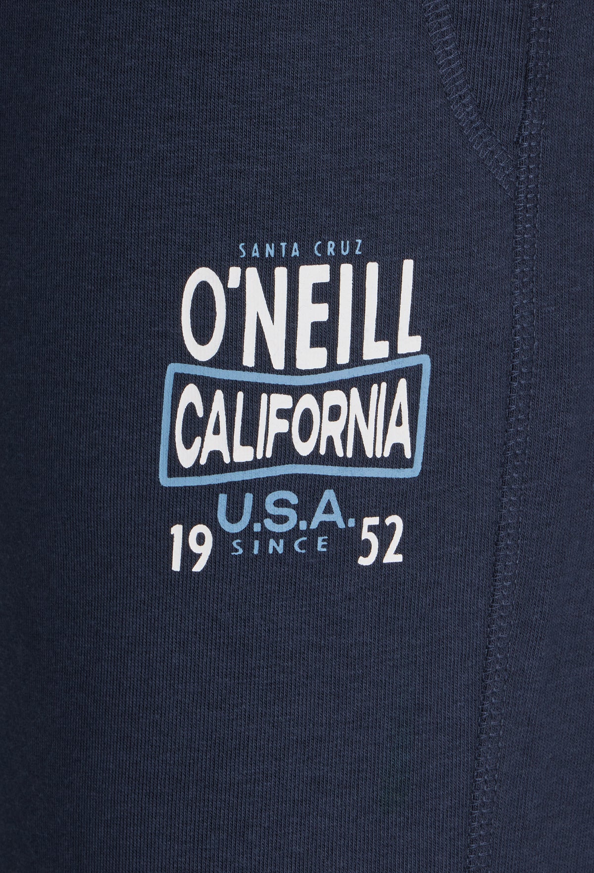 Nahaufnahme des Logo-Prints in Weiß und Hellblau auf der blauen CALI SWEATPANTS für Herren
