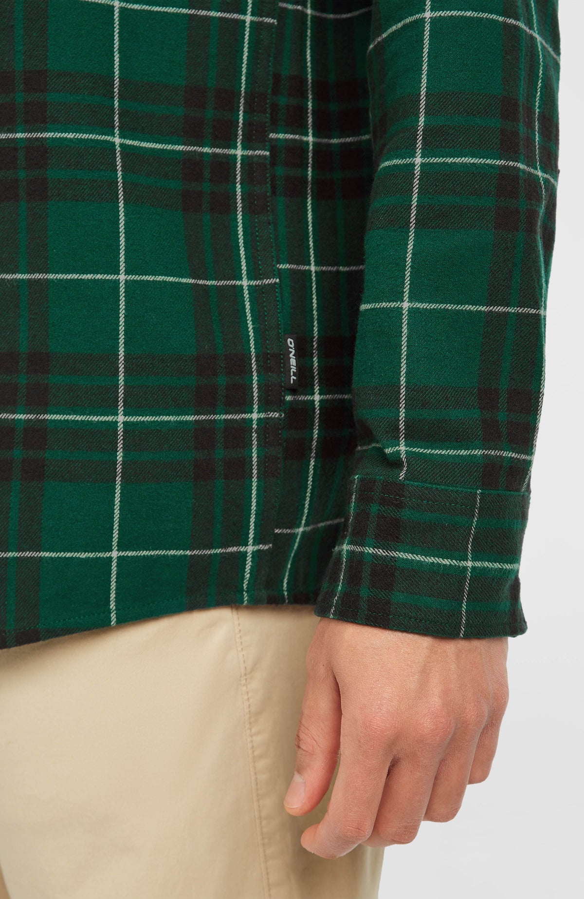 Must-Have Flanellhemd, grün mit Karomuster in Schwarz und Weiß, Nahaufnahme von Ärmelmanschette und kleinem Label