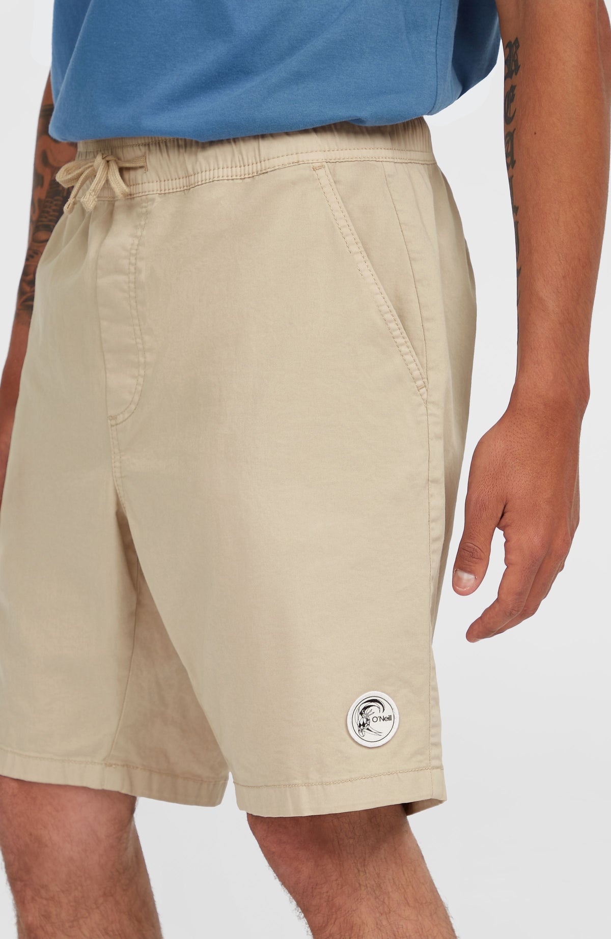 O'Riginals Walk Shorts für Herren, beige, Seitenansicht am Model mit Logo-Patch am Saum