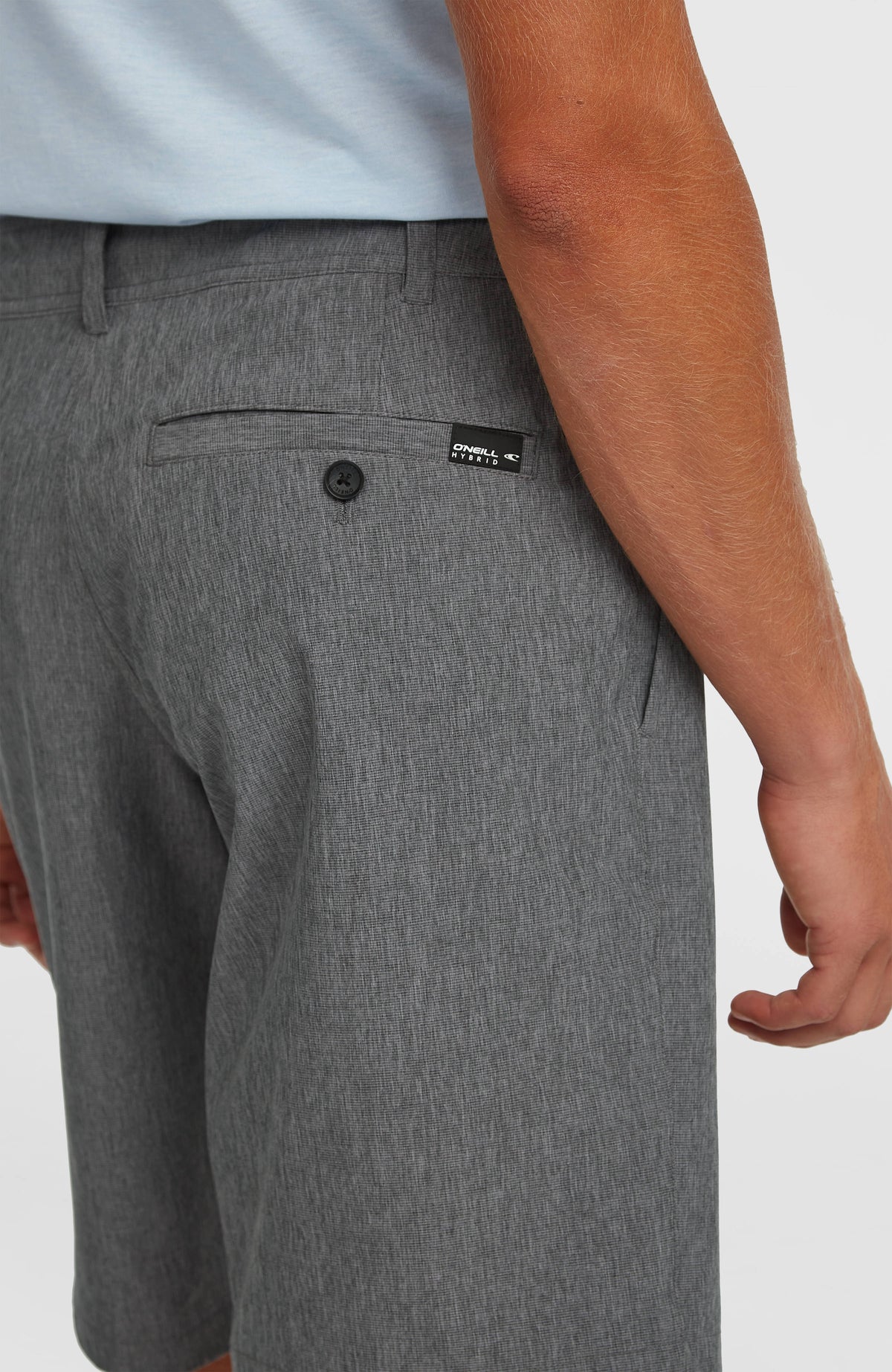 Nahaufnahme der schwarzen Hybrid 19" Melange Shorts für Herren, Paspeltasche mit Knopf und Logo-Aufnäher