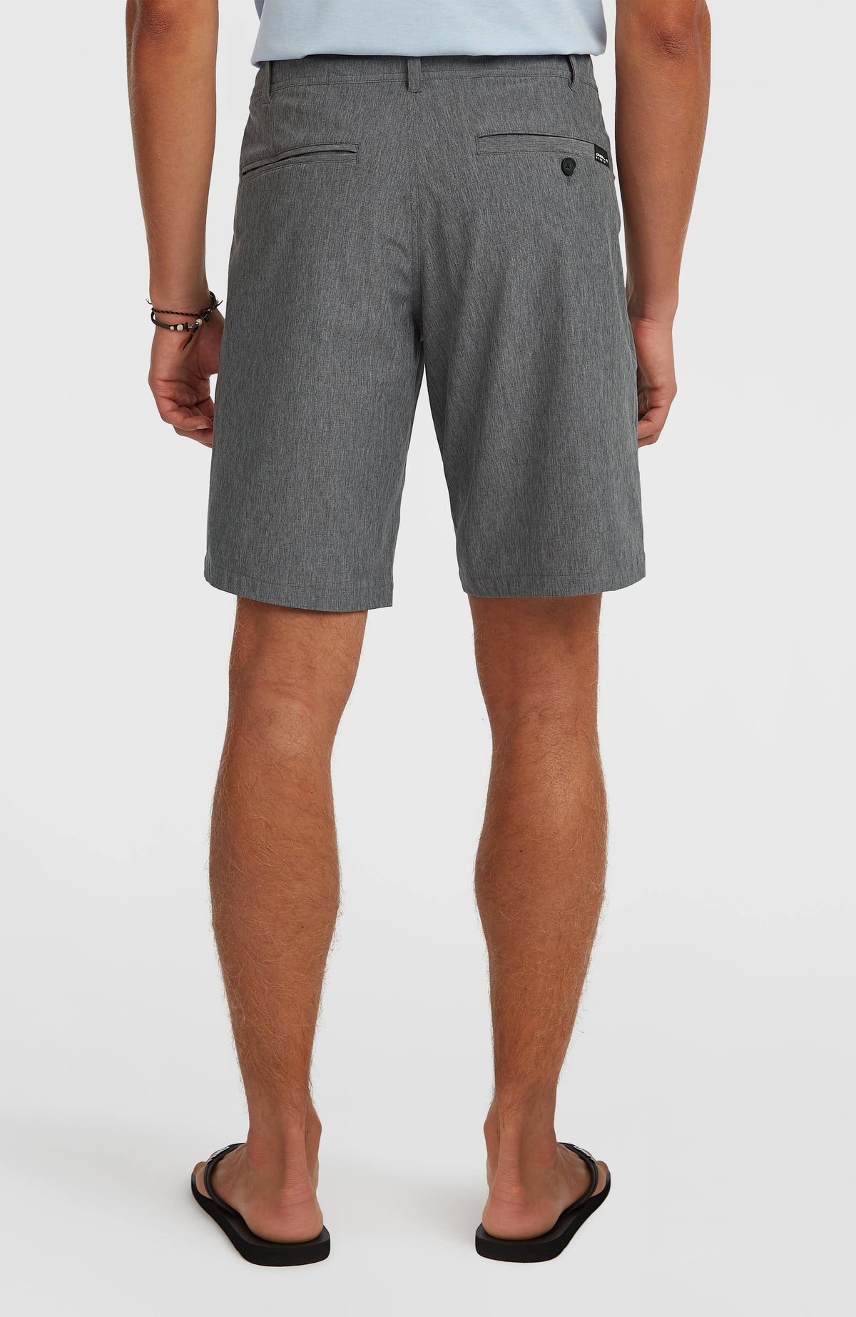 Hybrid 19" Melange Shorts für Herren, schwarz, getragen am Model, rückseitige Ansicht mit Paspeltaschen