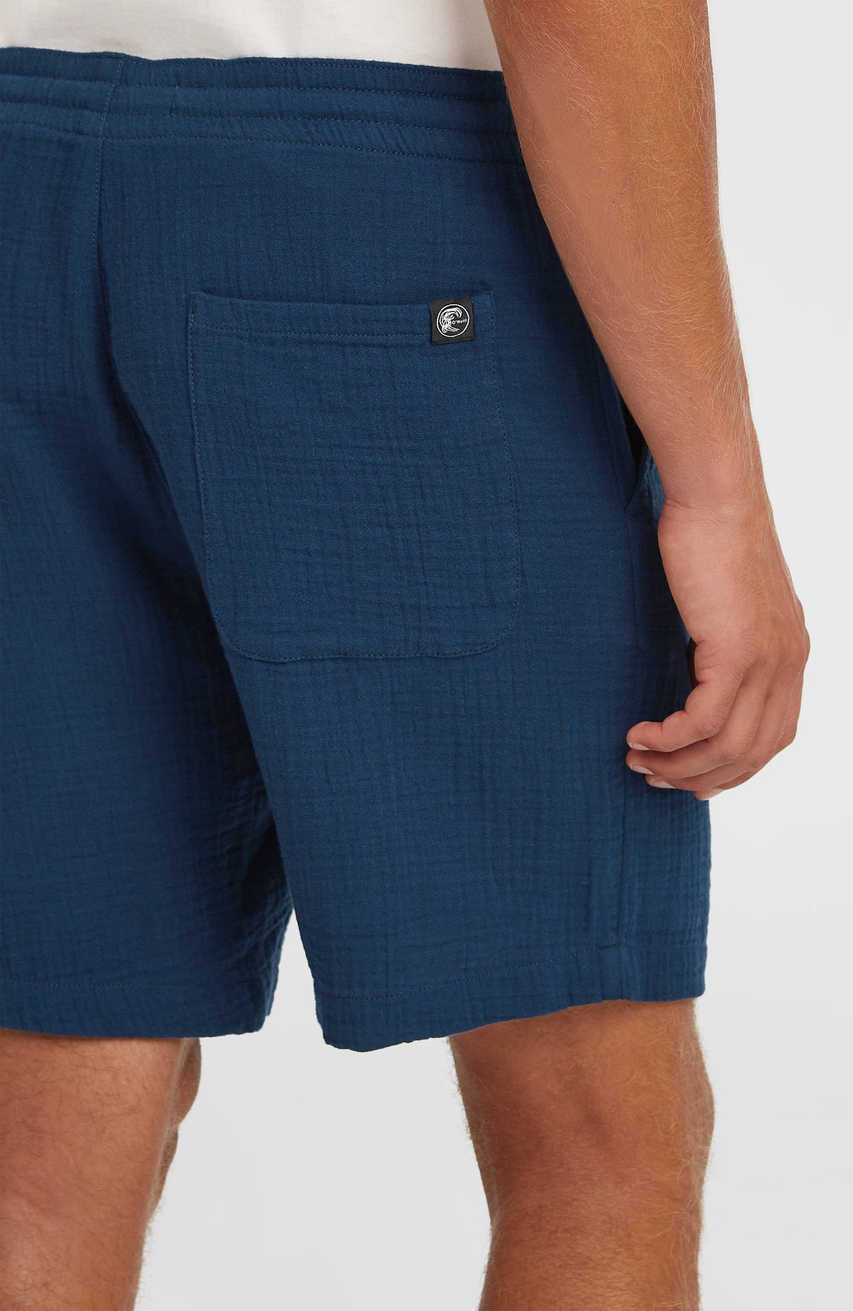 O'Riginals Structure Shorts für Herren, blau, Detailansicht am Model mit aufgesetzter Gesäßtasche und Logo-Patch