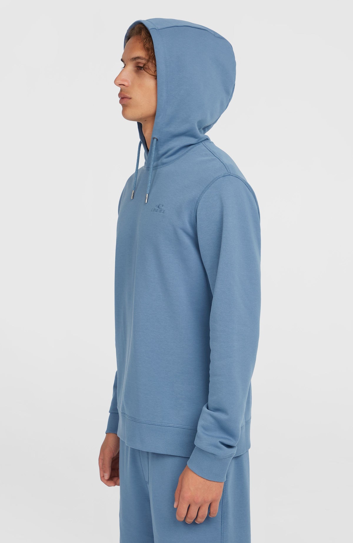 Small Logo Hoodie für Herren, blau, getragen am Model in Seitenansicht mit aufgesetzter Kapuze