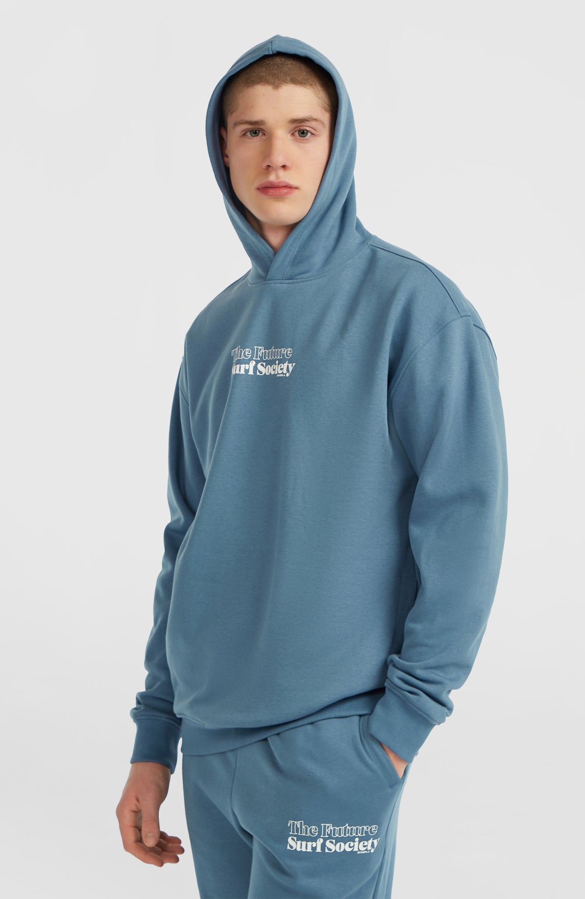 Future Surf Society Hoodie für Herren, blau, Halbprofilansicht am Model mit aufgesetzter Kapuze