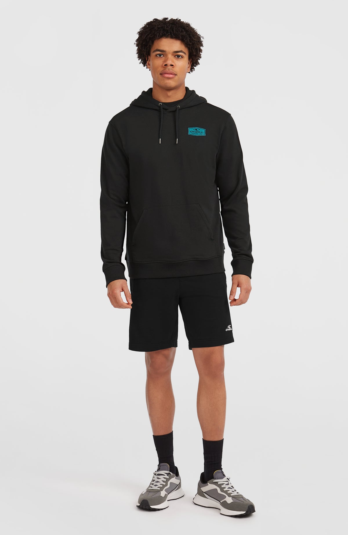 Graphic Hoodie für Herren, schwarz mit Logo-Print in Türkis, Ganzkörperansicht am Model