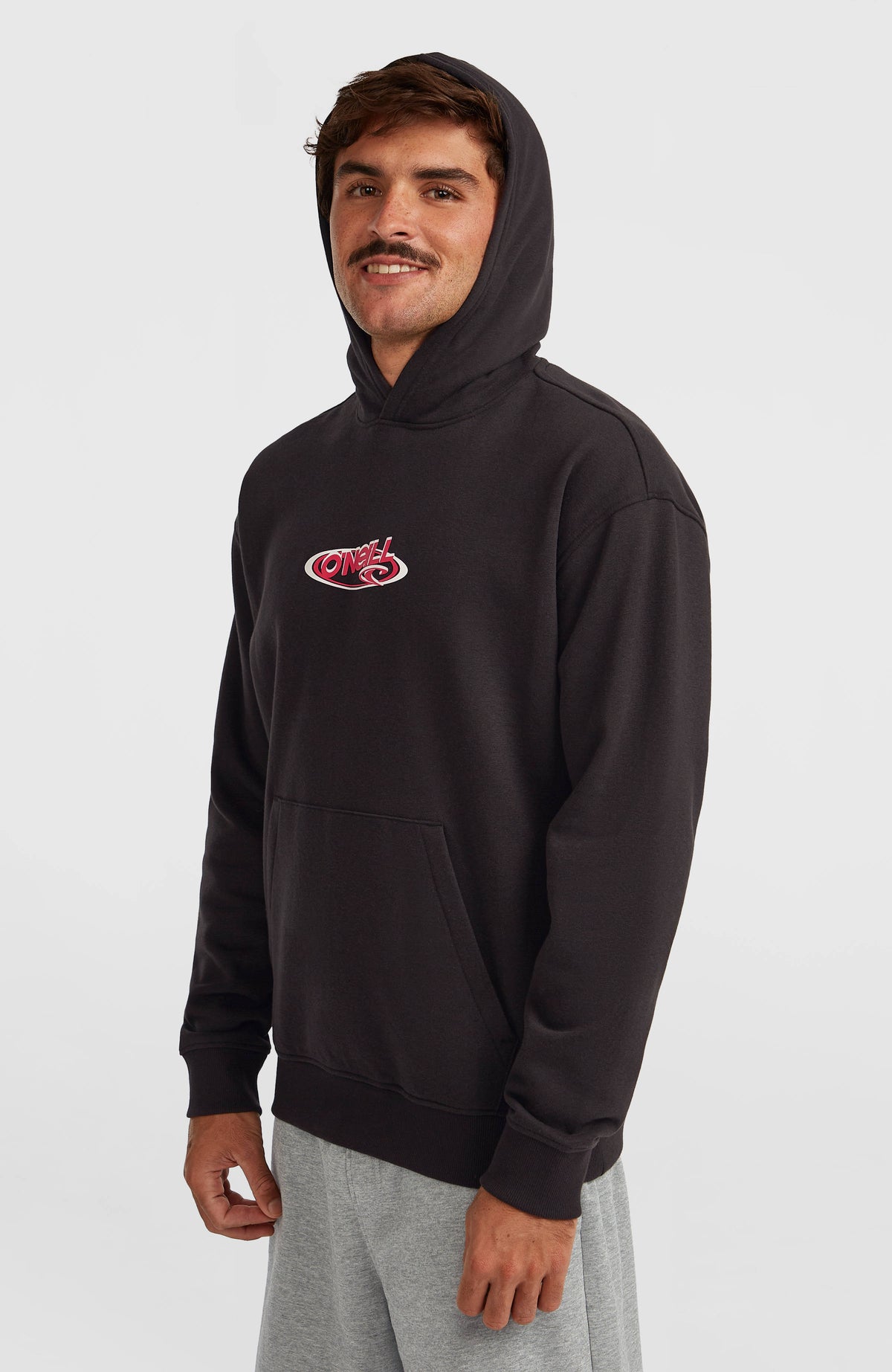 Essentials 90s Logo Hoodie für Herren in Schwarz, getragen am Model mit aufgesetzter Kapuze, Halbprofil