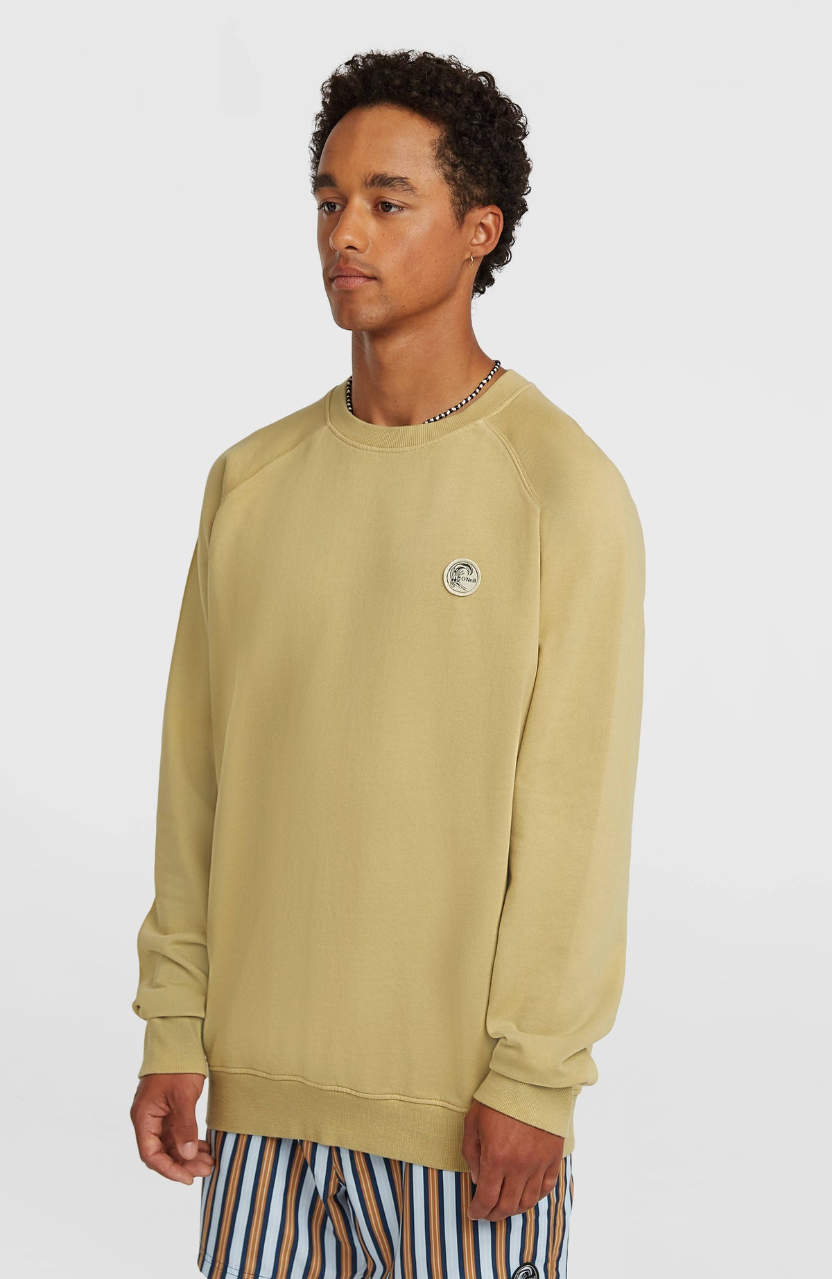 O'Riginals Badge Crew Sweatshirt für Herren in Beige, schräge Vorderansicht am Model