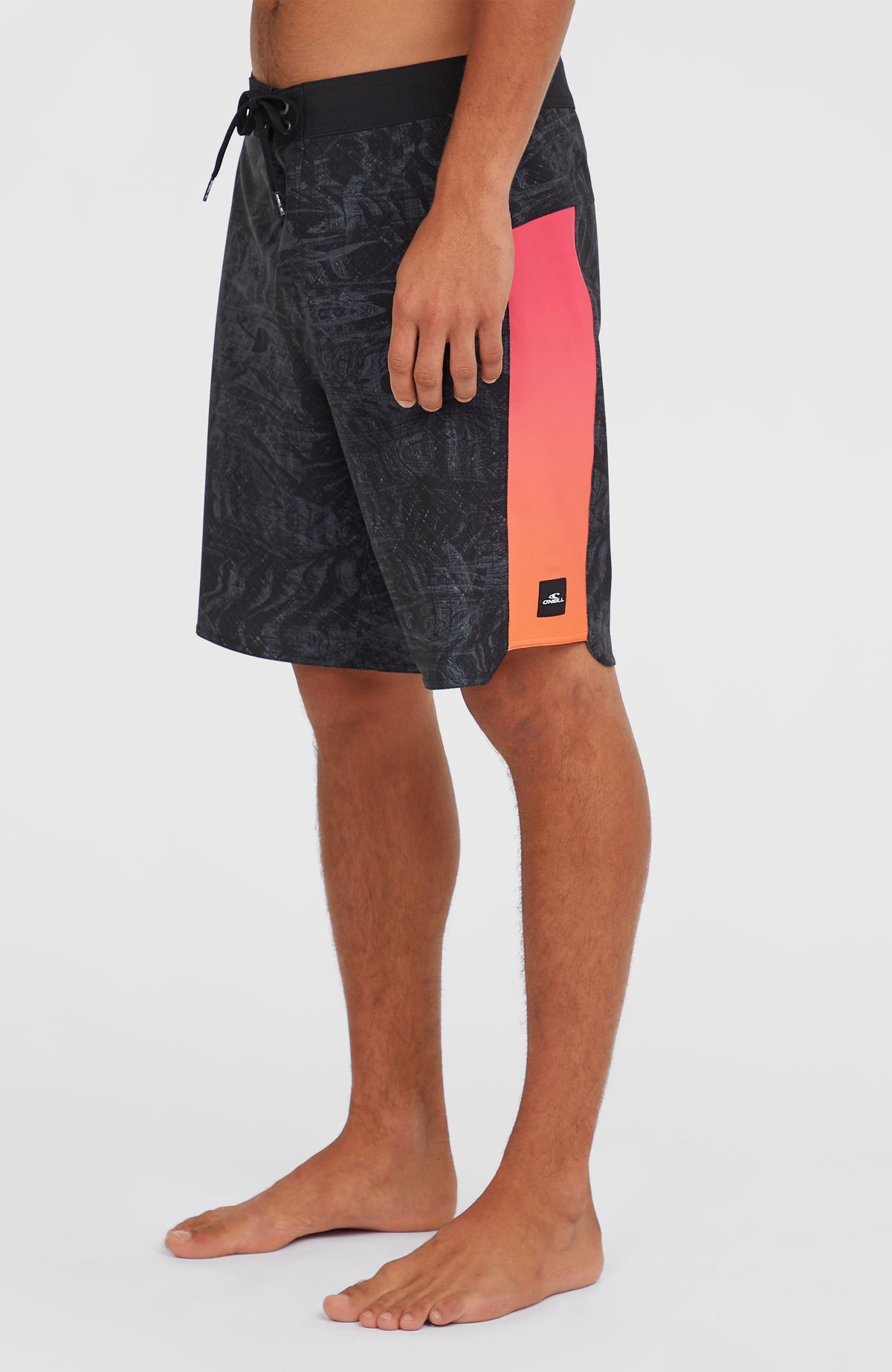 Hyperfreak Tech Panel 19'' Boardshorts, schwarz mit Farbverlauf in Pink und Orange, Seitenansicht mit Logo-Patch am Saum