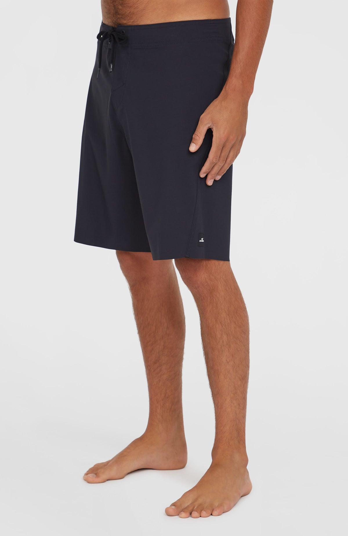 Hyperfreak Tech Solid 19'' Boardshorts, schwarz, Seitenansicht am Model mit Logo-Detail am Saum