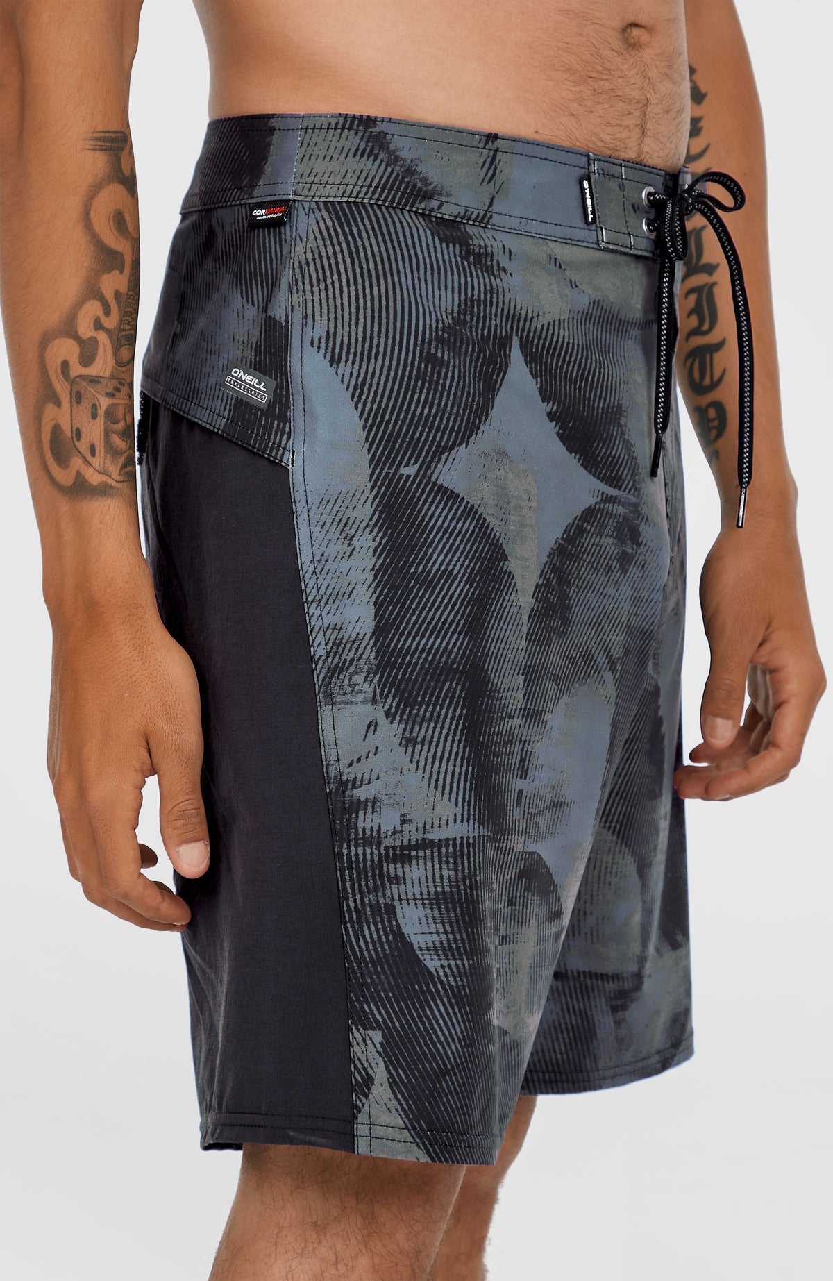 Tech Enduro 20'' Boardshorts für Herren, grün mit Grafikmuster in Schwarz, Detailansicht am Model mit Markenlabel