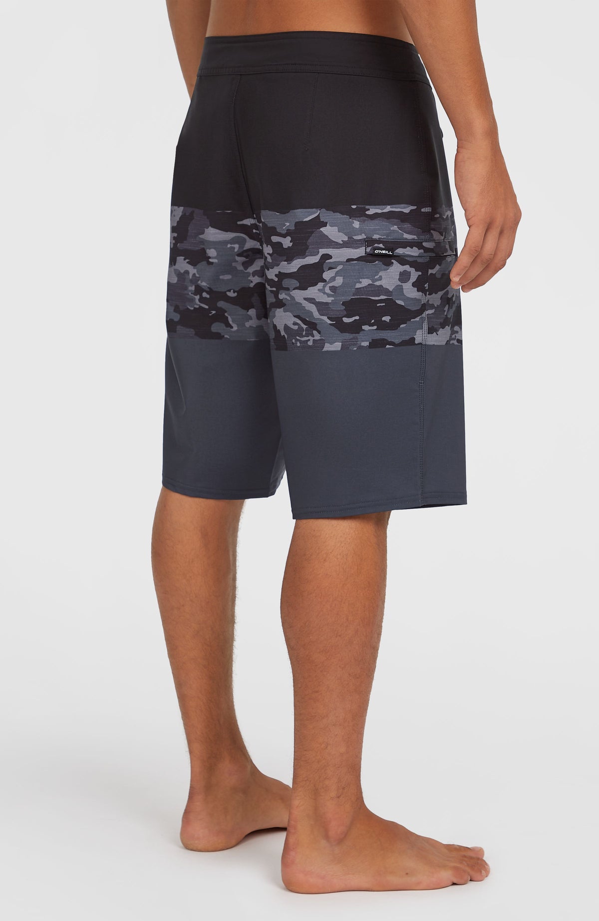 Hyperfreak Heat Block 21'' Boardshorts, schwarz mit Camouflage-Muster in Grau, halbe Rückansicht getragen am Model