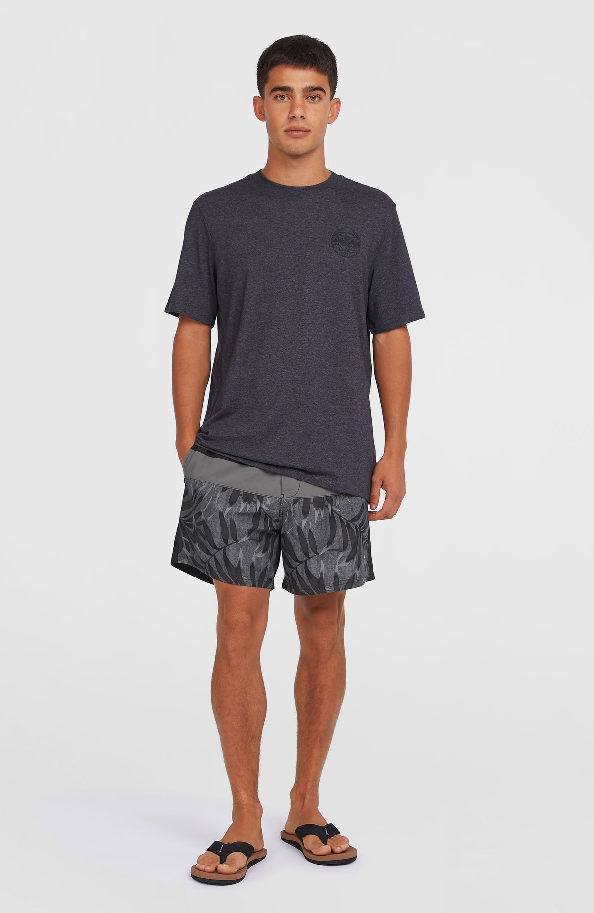 Cali Block 15'' Badehose für Herren, schwarz mit Blättermuster in Grau, getragen am Model mit T-Shirt