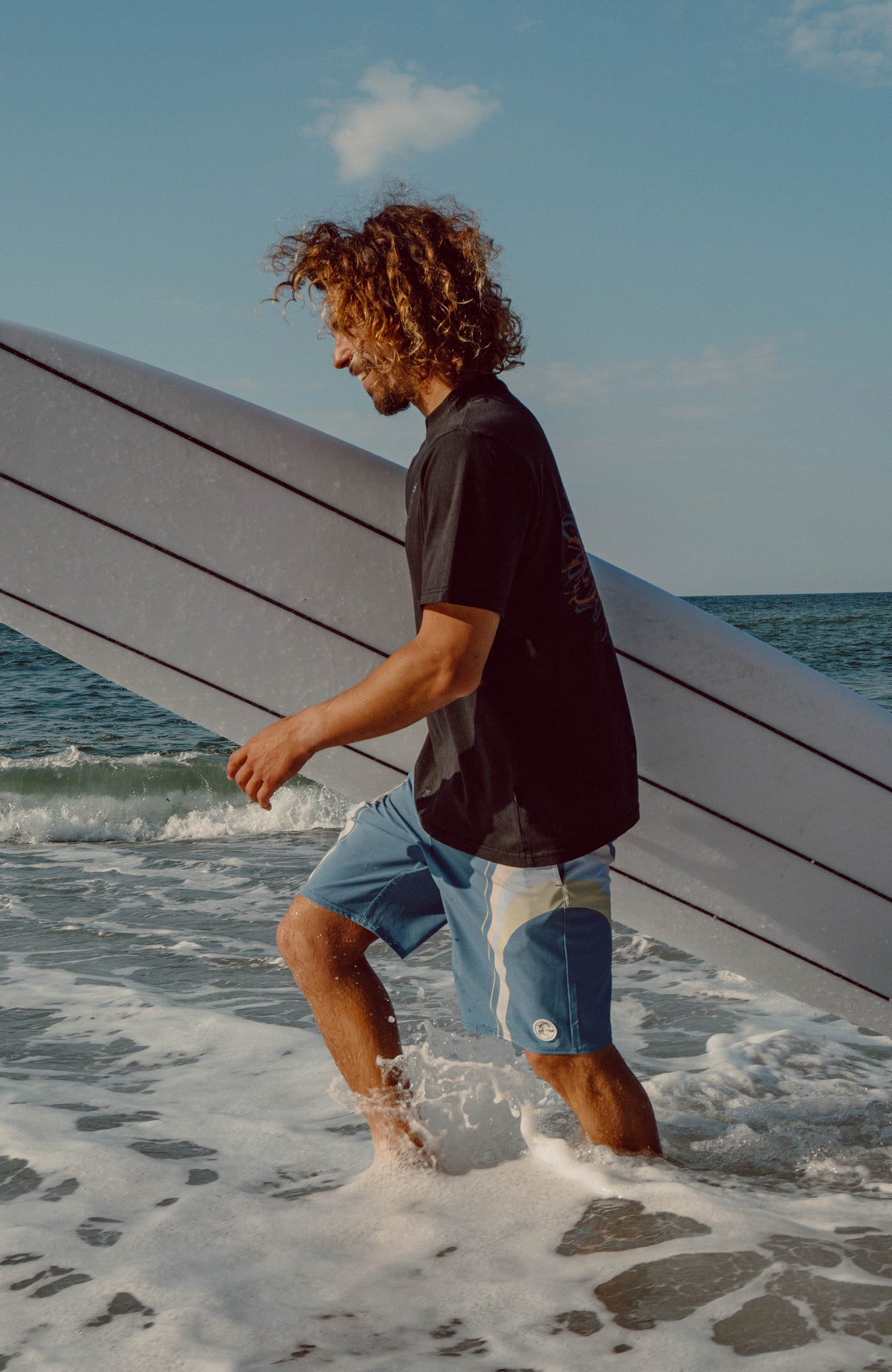 O'Riginals Longboard 19'' Boardshorts für Herren, blau mit Streifenmuster in Weiß und Grün, am Strand im Wasser