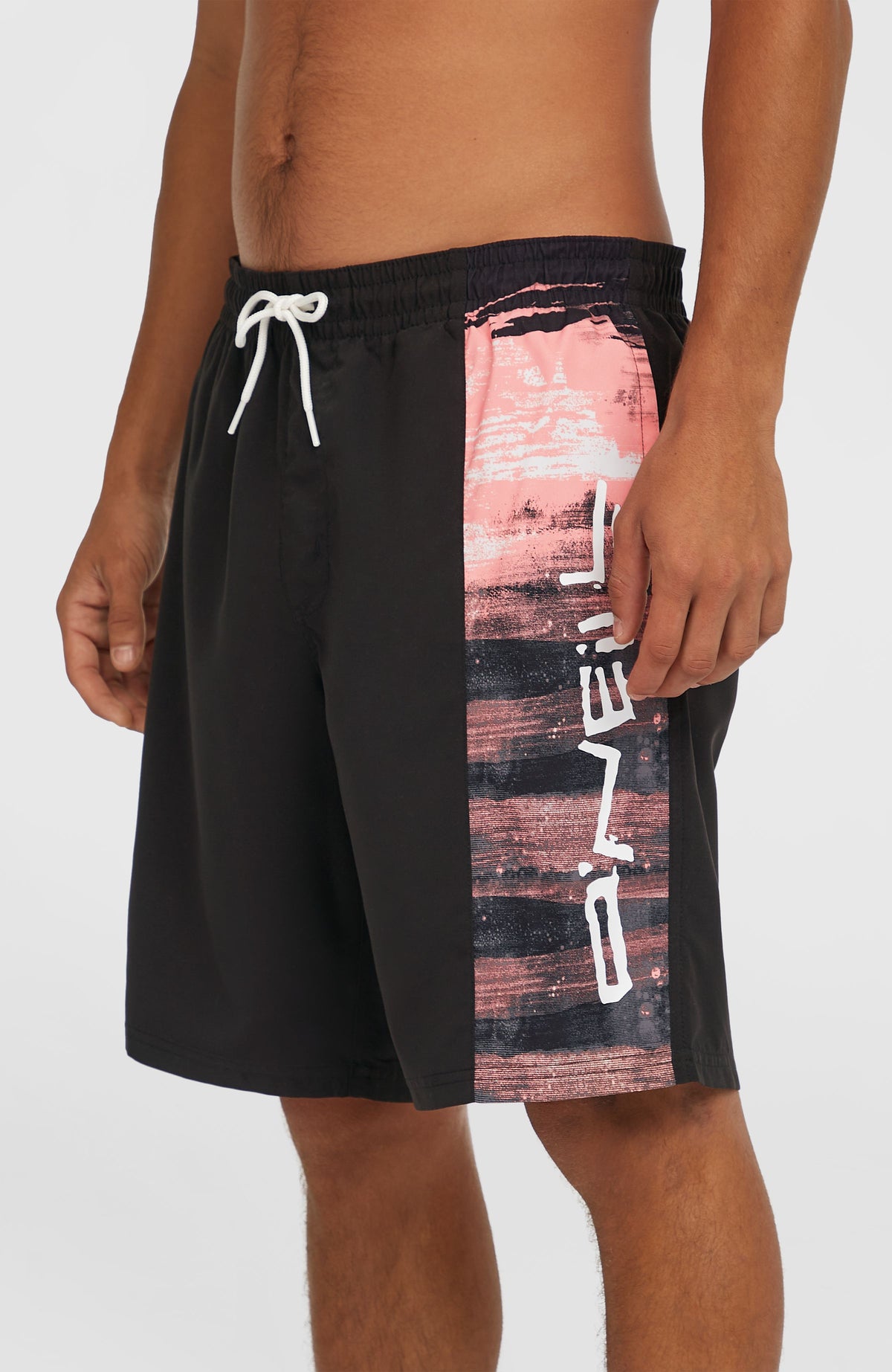 Retro 19'' Badehose für Herren, pink mit Logo-Print in Schwarz und Weiß, Seitenansicht mit Streifendetail am Model