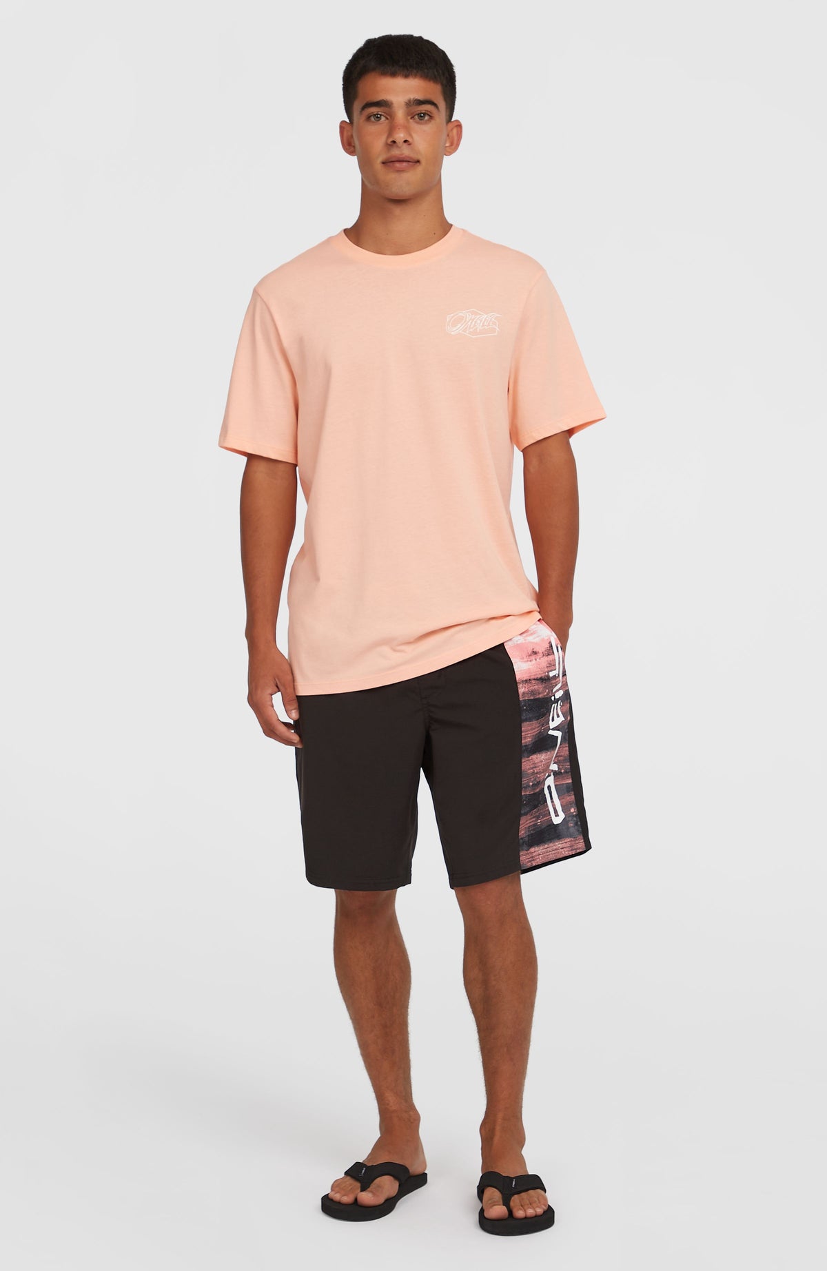 Retro 19'' Badehose für Herren, pink mit Logo-Print in Schwarz und Weiß, getragen am Model in Ganzkörperansicht