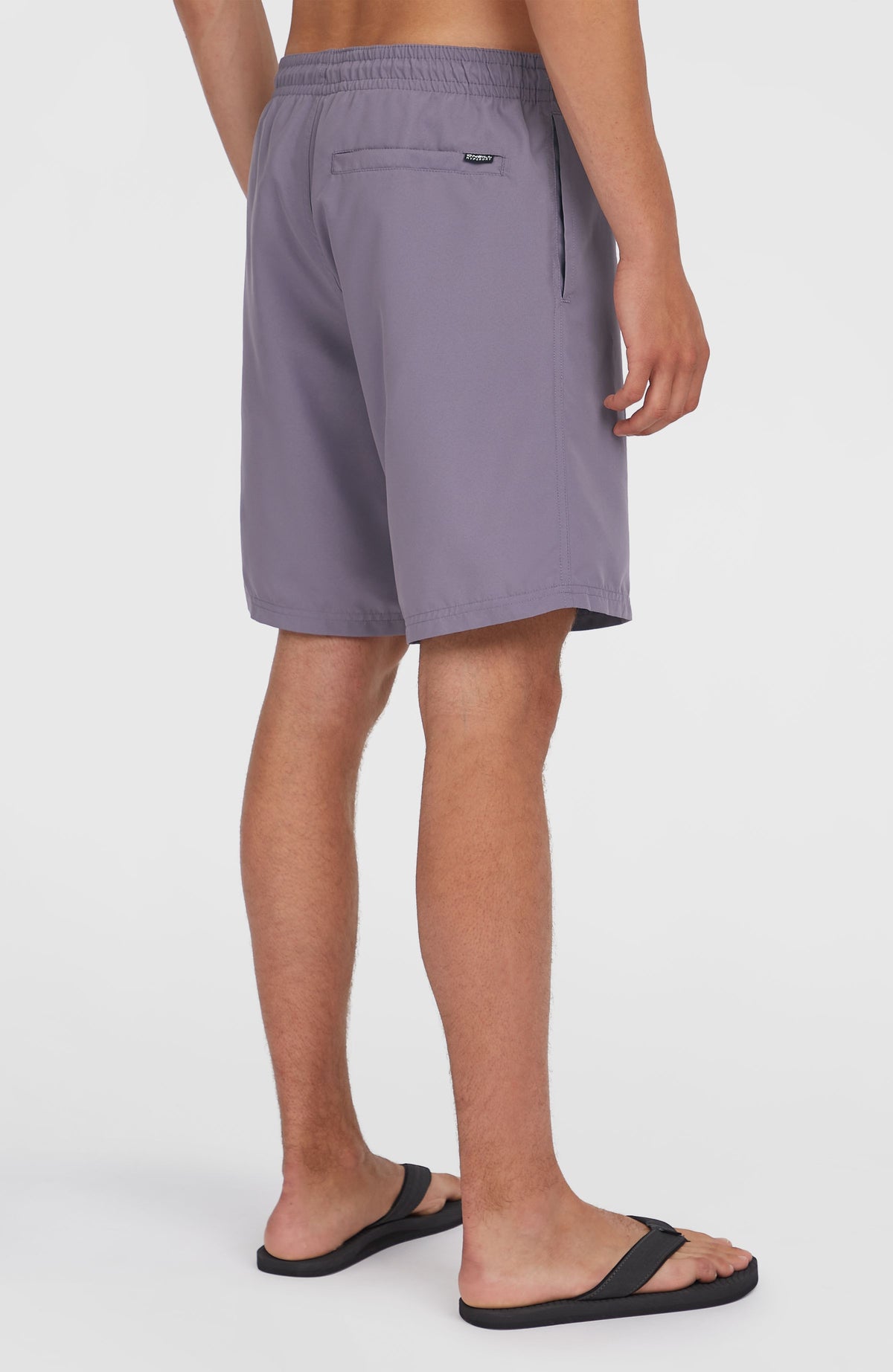 Retro 19'' Badehose für Herren, lila mit Logo-Print in Mintgrün, Rückansicht am Model mit Gesäßtasche