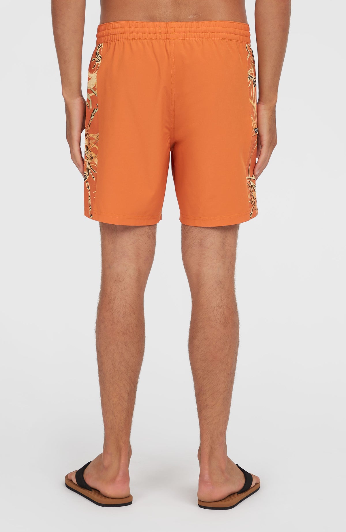 O'Riginals Side Panel 16'' Badehose für Herren, orange mit Grafikmuster in Beige, Rückansicht am Model mit elastischem Bund