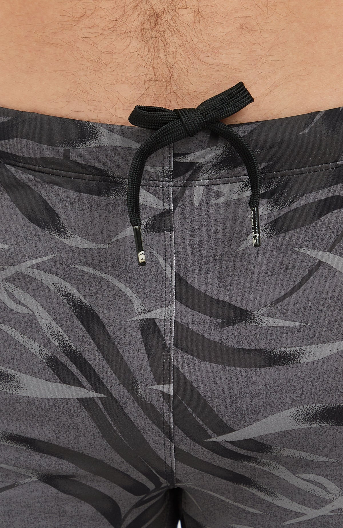 Nahaufnahme von Bund und Kordelzug der schwarzen Essentials Floral Racer Badehose mit Blättermuster in Grau