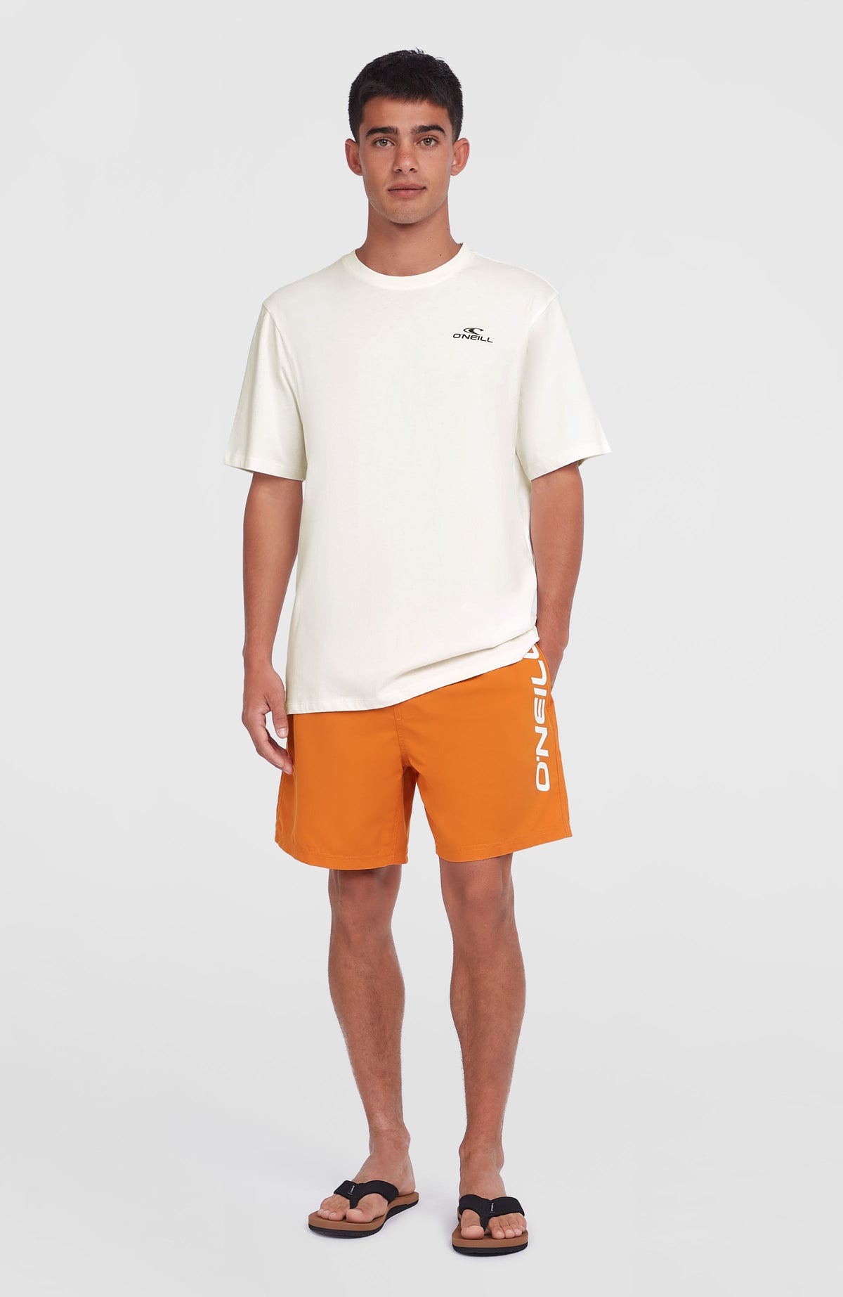 Cali 16'' Badehose für Herren, orange mit Logo-Print in Weiß, getragen am Model in Ganzkörperansicht
