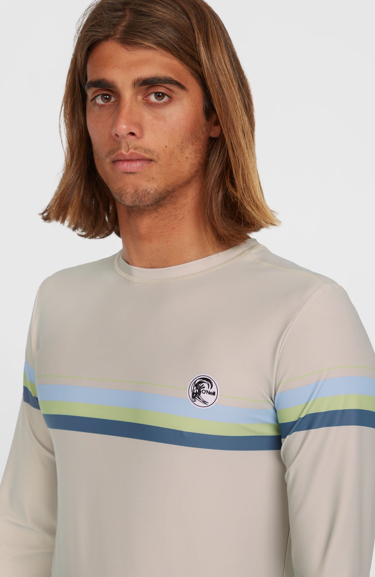 Nahaufnahme des beigen O'Riginals Longsleeve-Schwimmshirts mit Streifenmuster und rundem Logo-Badge auf der Brust