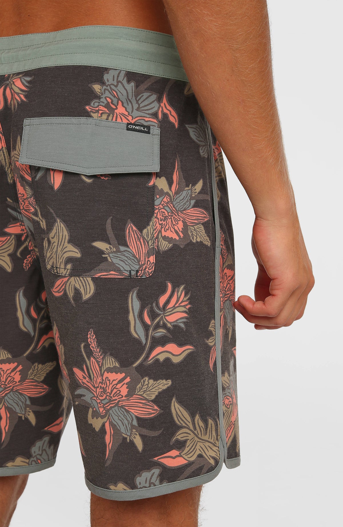 Nahaufnahme der Gesäßtasche mit Klappe an der schwarzen Cruzer Scallop 18'' Boardshorts mit Blumenmuster