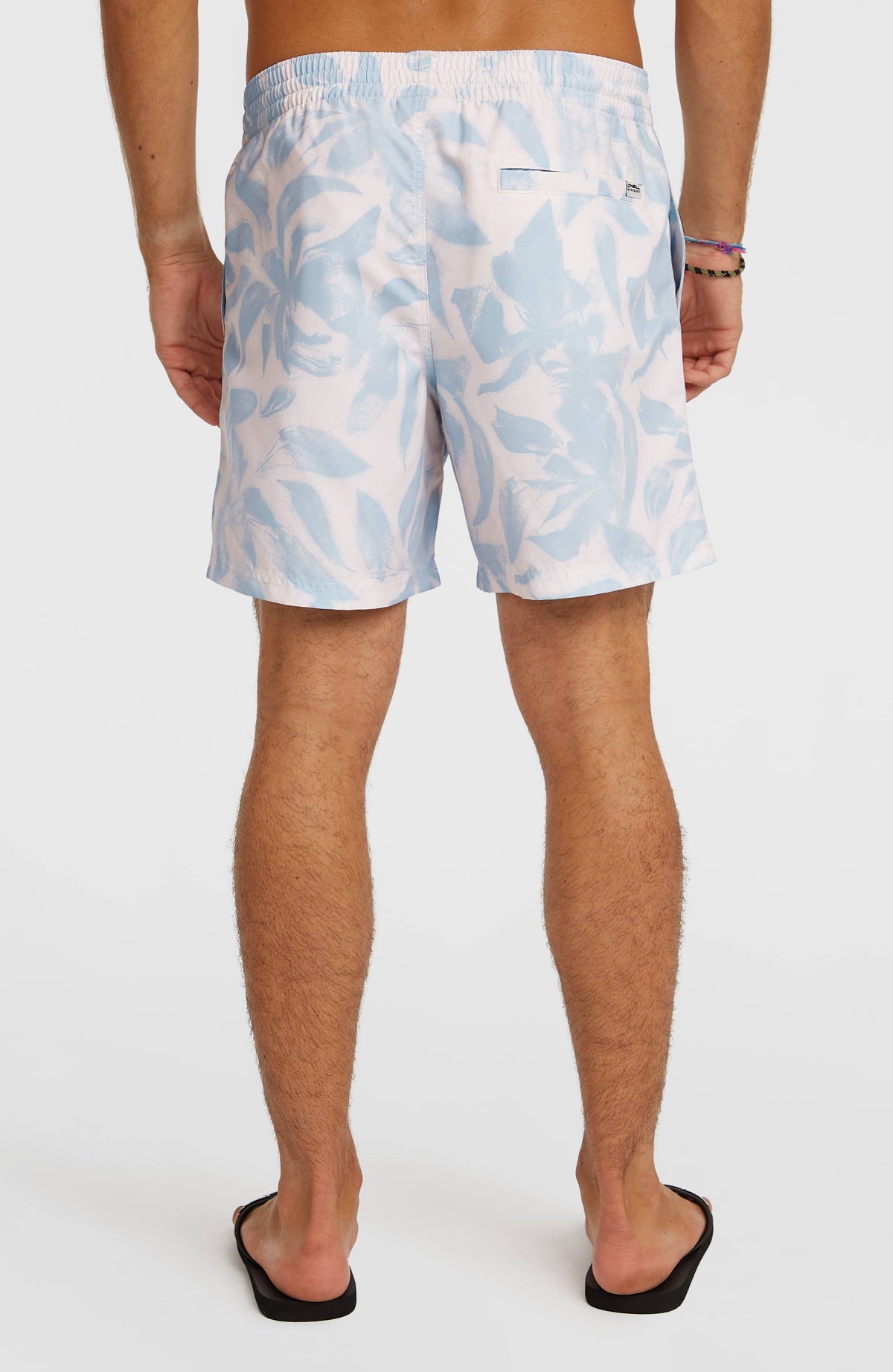 Print 16'' Badehose für Herren, weiß mit Blumenmuster in Hellblau, Rückansicht mit Gesäßtasche am Model
