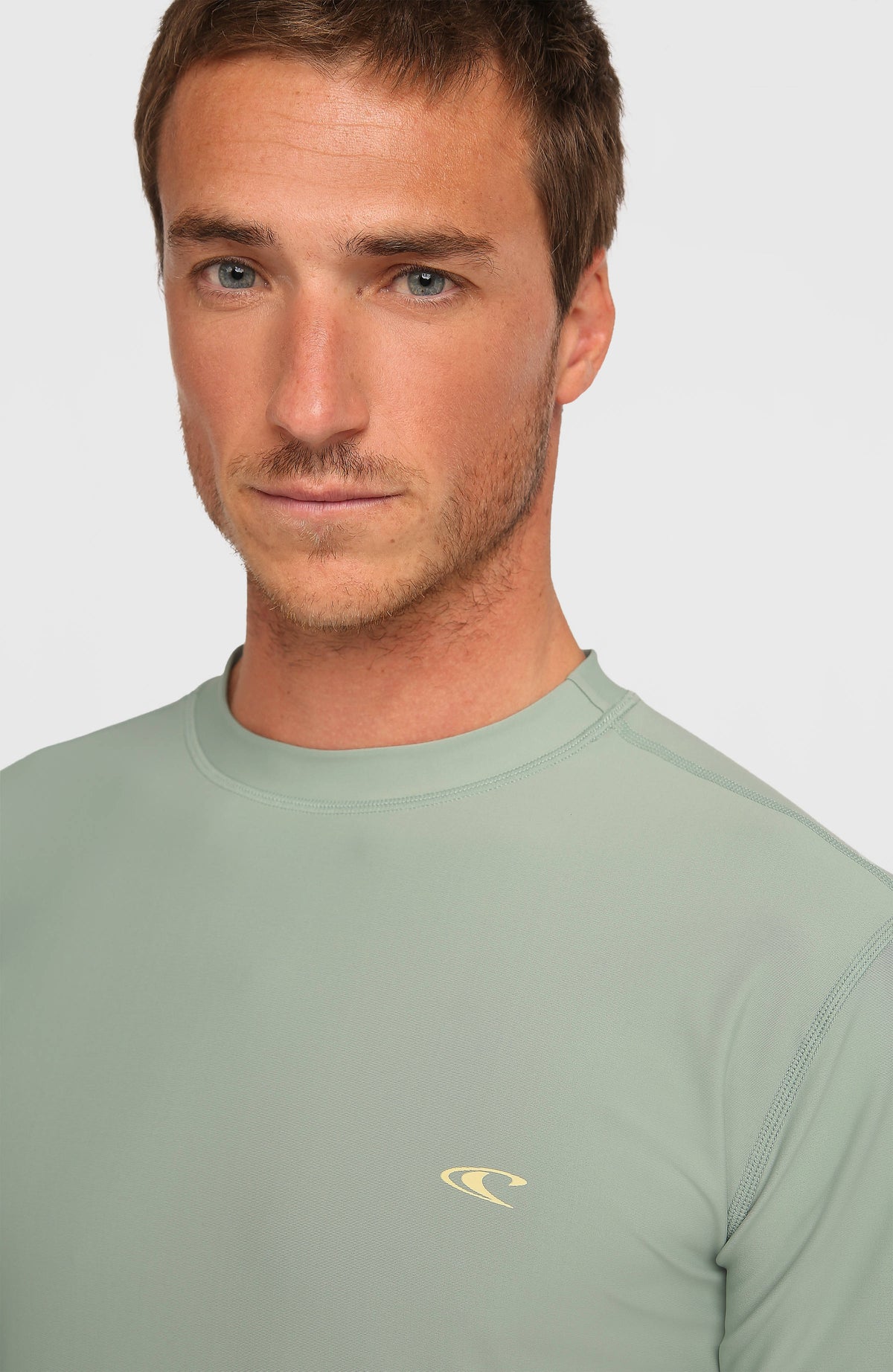Nahaufnahme des Rundhalsausschnitts und des kleinen Logo-Prints auf dem grünen Longsleeve-UV-Shirt für Herren