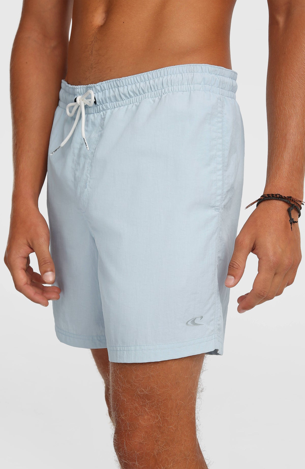 Vert 16'' Badehose, blau, Nahaufnahme der Seitenansicht am Model mit Logo am Saum