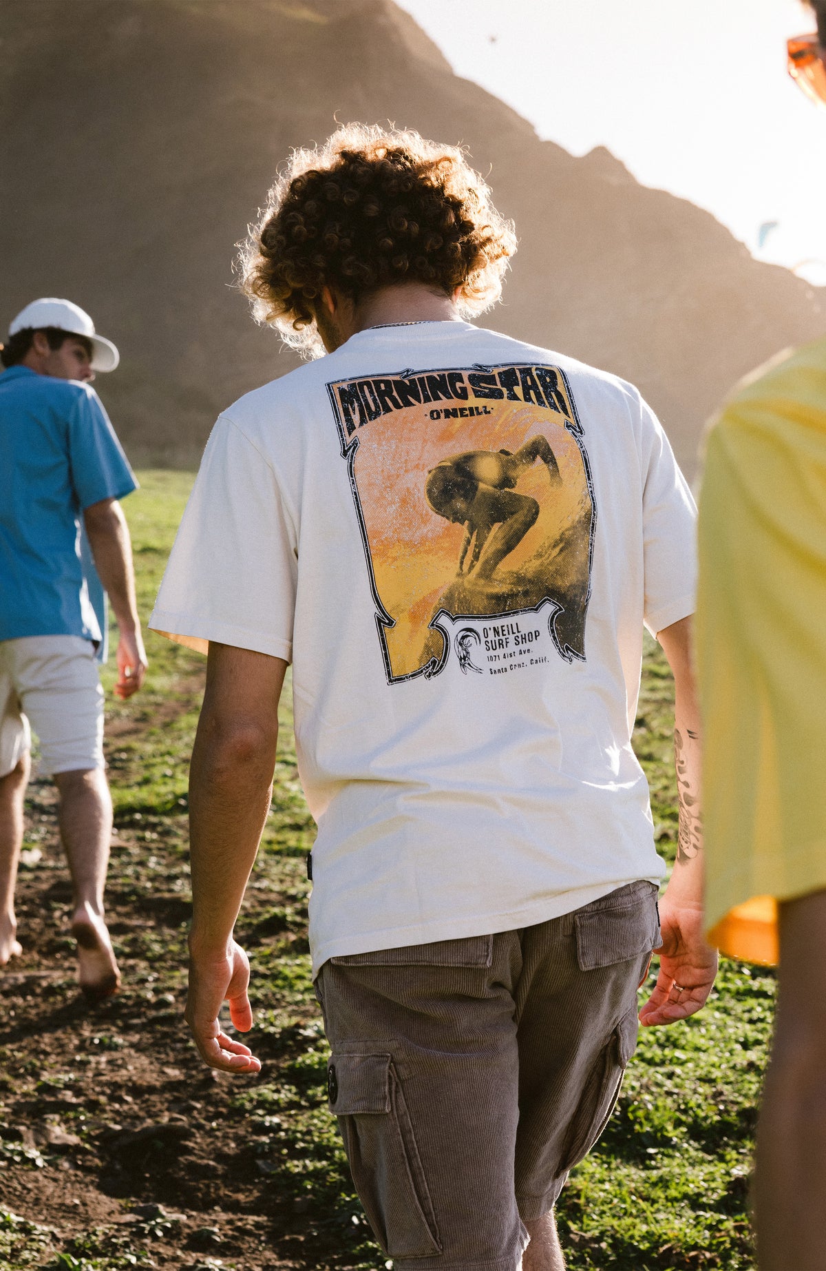 O'Riginals 70s Graphic T-Shirt, beige mit Grafik-Print in Gelb und Schwarz, Rückansicht in der Natur getragen am Model