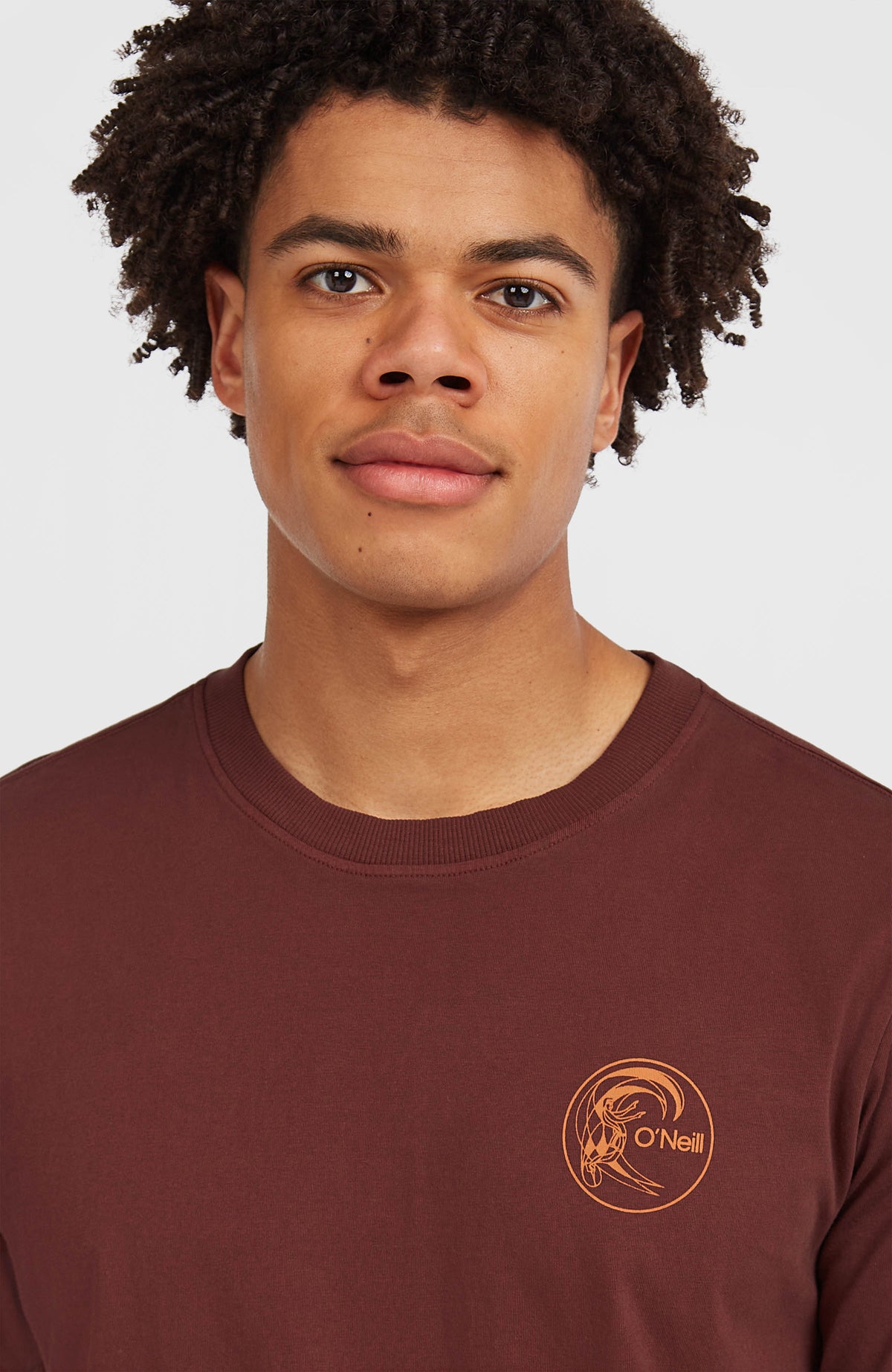 Nahaufnahme von Rundhalsausschnitt und kleinem Logo-Print des braunen O'Riginals Retro Back-Print T-Shirts