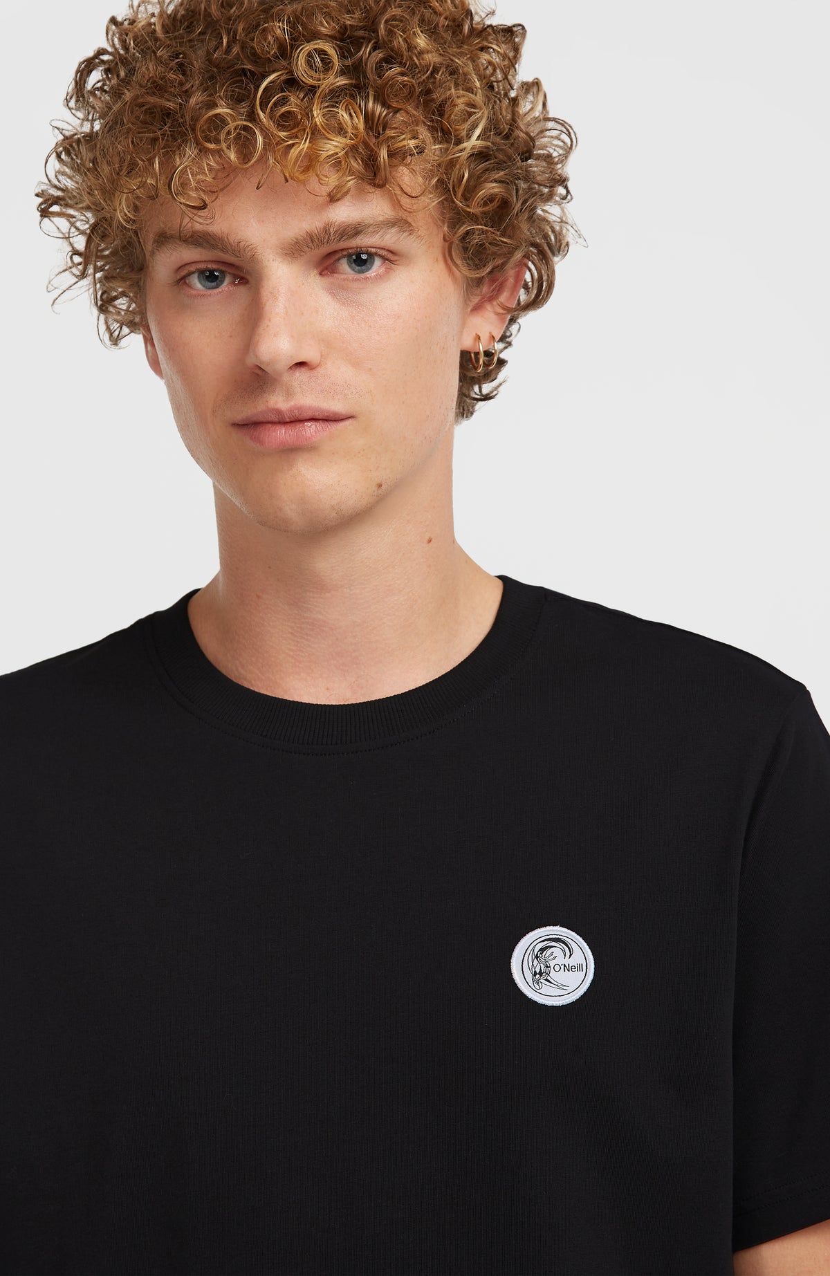 Nahaufnahme von rundem Logo-Badge und Rundhalsausschnitt am schwarzen O'Riginals Badge T-Shirt
