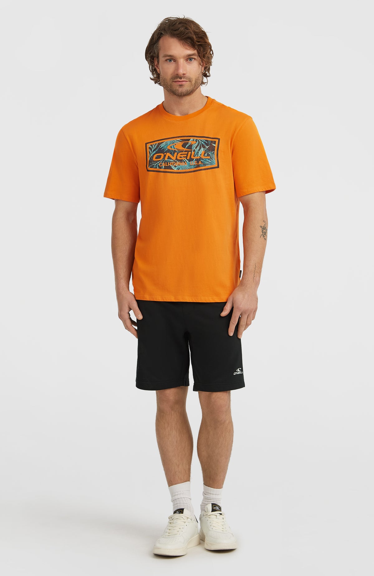 Graphic T-Shirt für Herren, orange mit Logo-Print in Türkis, Ganzkörperansicht am Model