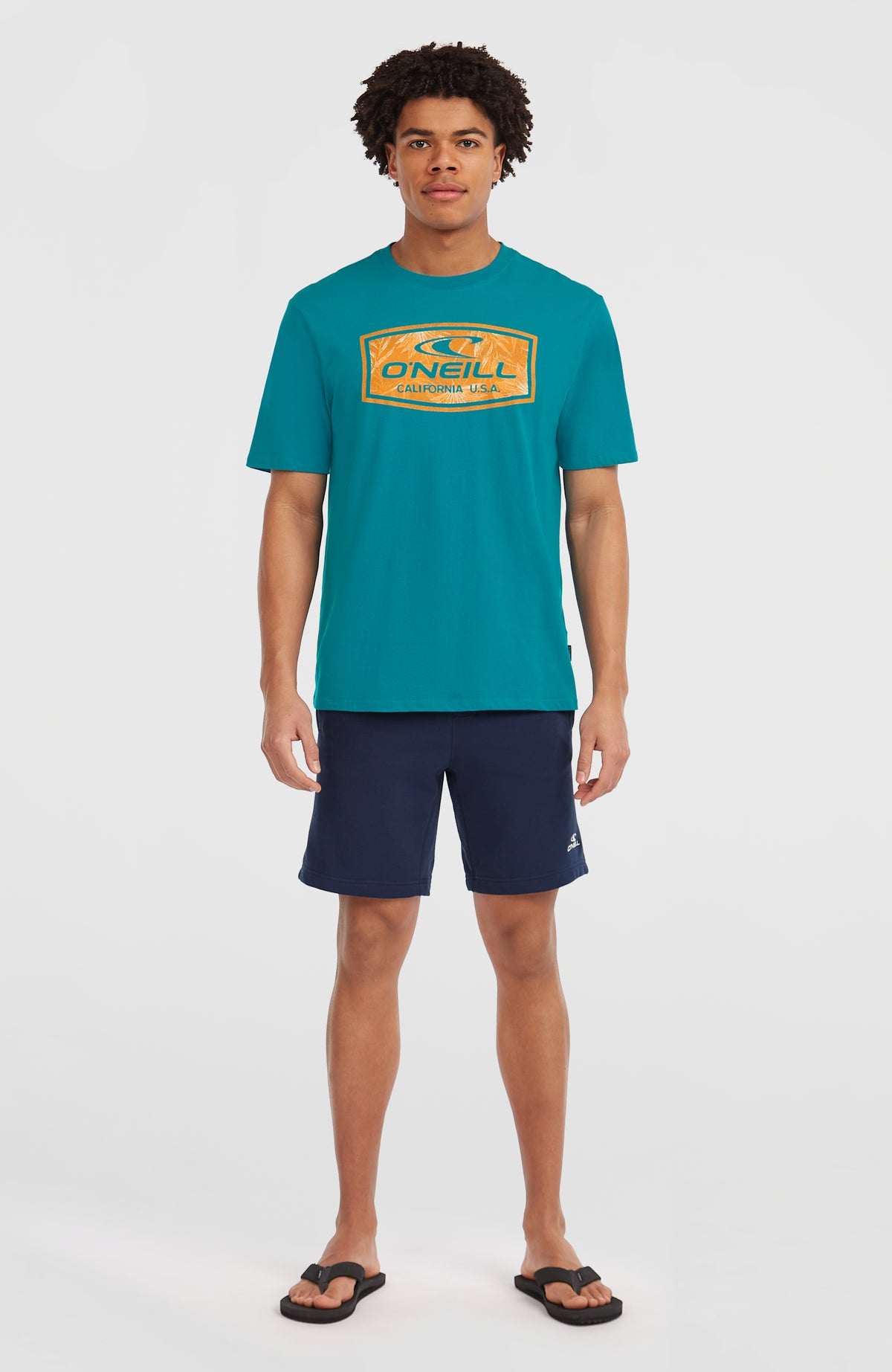 Graphic T-Shirt für Herren, blau mit Logo-Print in Orange, stehende Ganzkörperansicht von vorne am Model