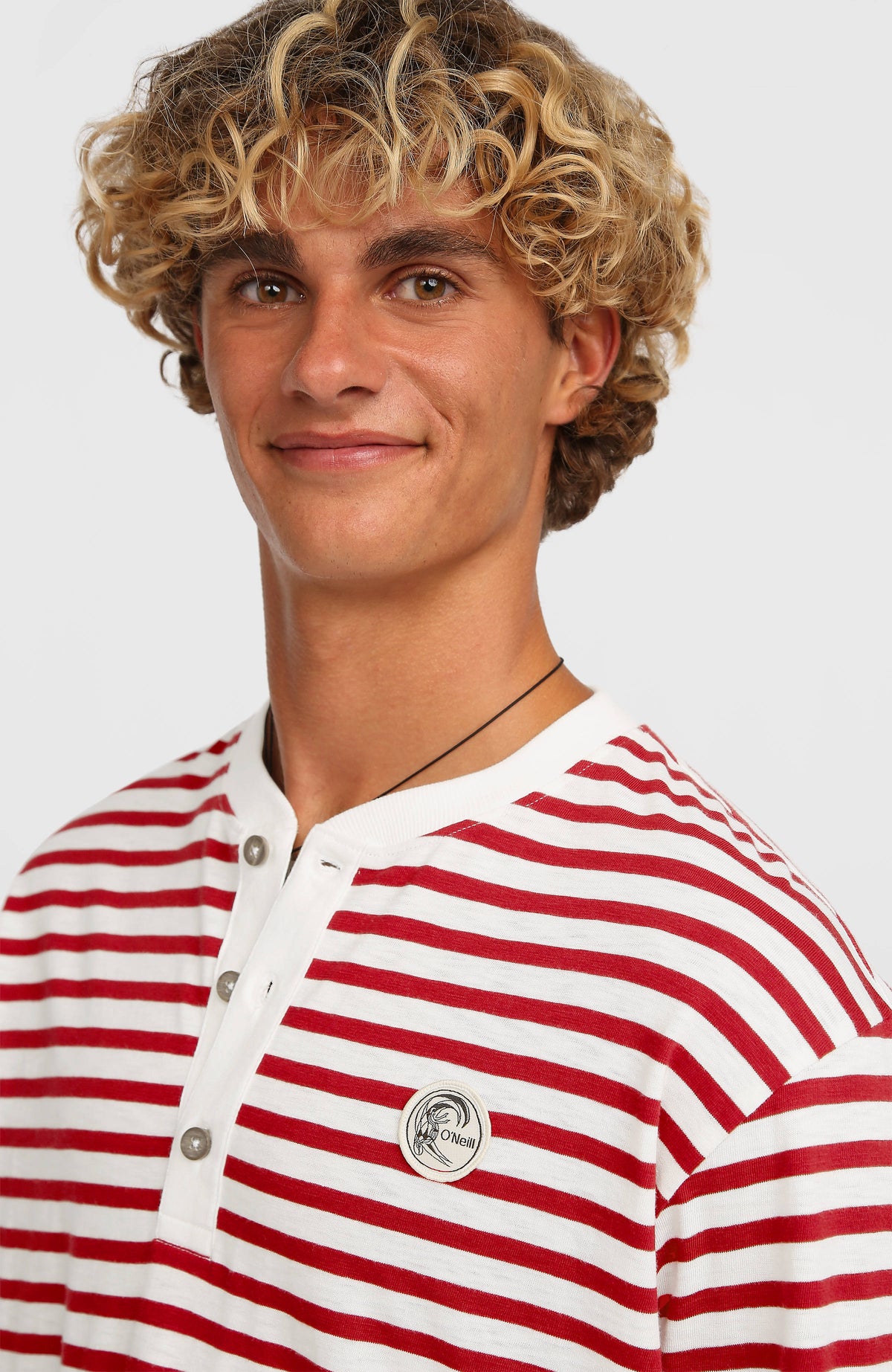 Nahaufnahme von Knopfleiste und Logo-Badge am weißen O'Riginals Langarmshirt mit Streifenmuster in Rot