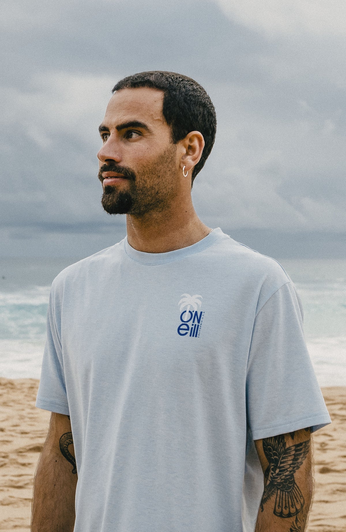 Hybrid Polygiene Graphic T-Shirt für Herren, blau, am Strand, seitliche Ansicht am Model